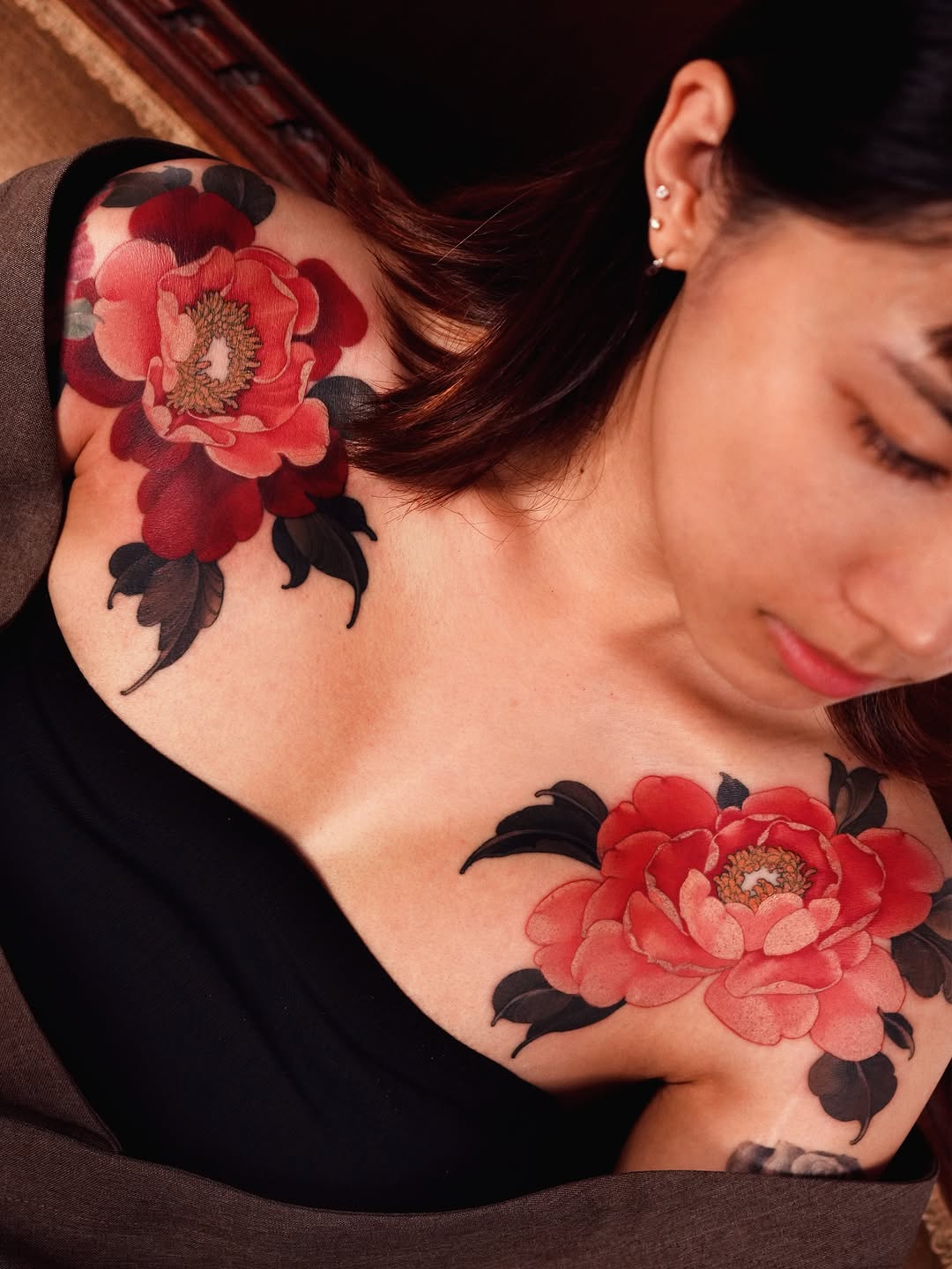 Neo-traditional red peonies spanning both shoulders.