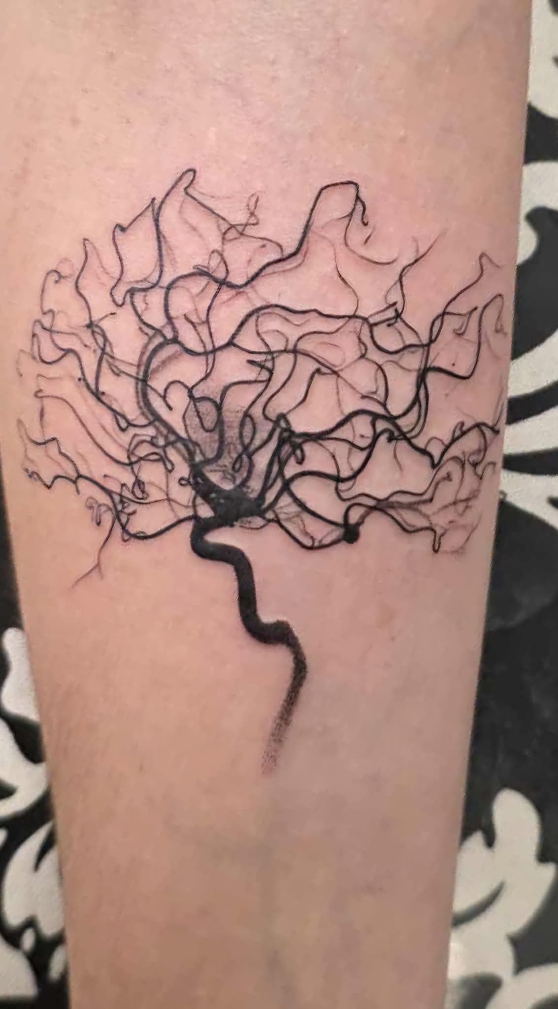 Tangled, branching tree silhouette in fine black linework.