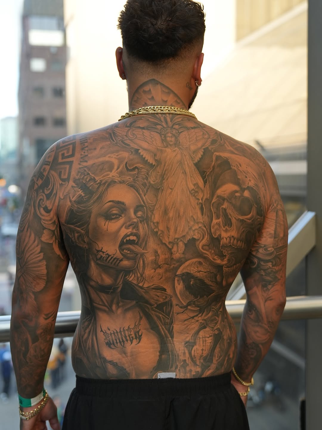 Monumental black-and-gray backpiece with angelic wings and skull