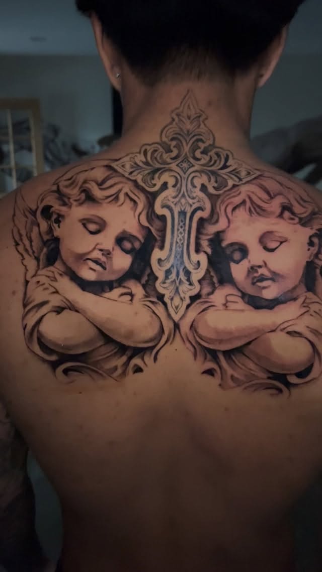 Two cherubic angels frame ornate gothic centerpiece on back