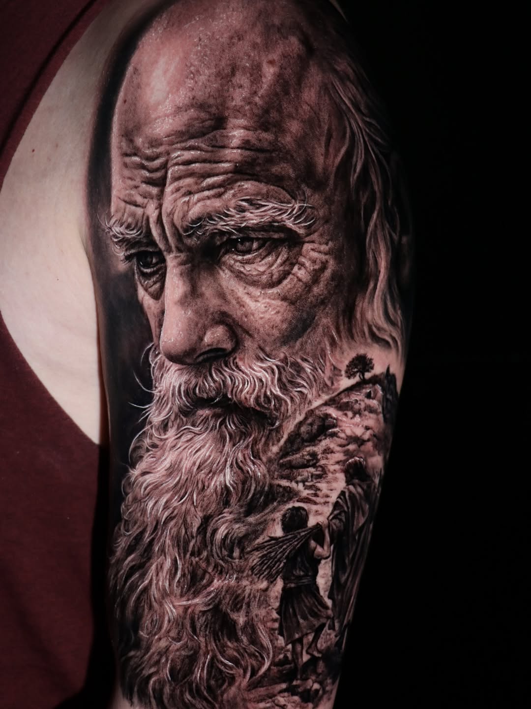 Intricately textured black-and-gray realism portrait on upper arm