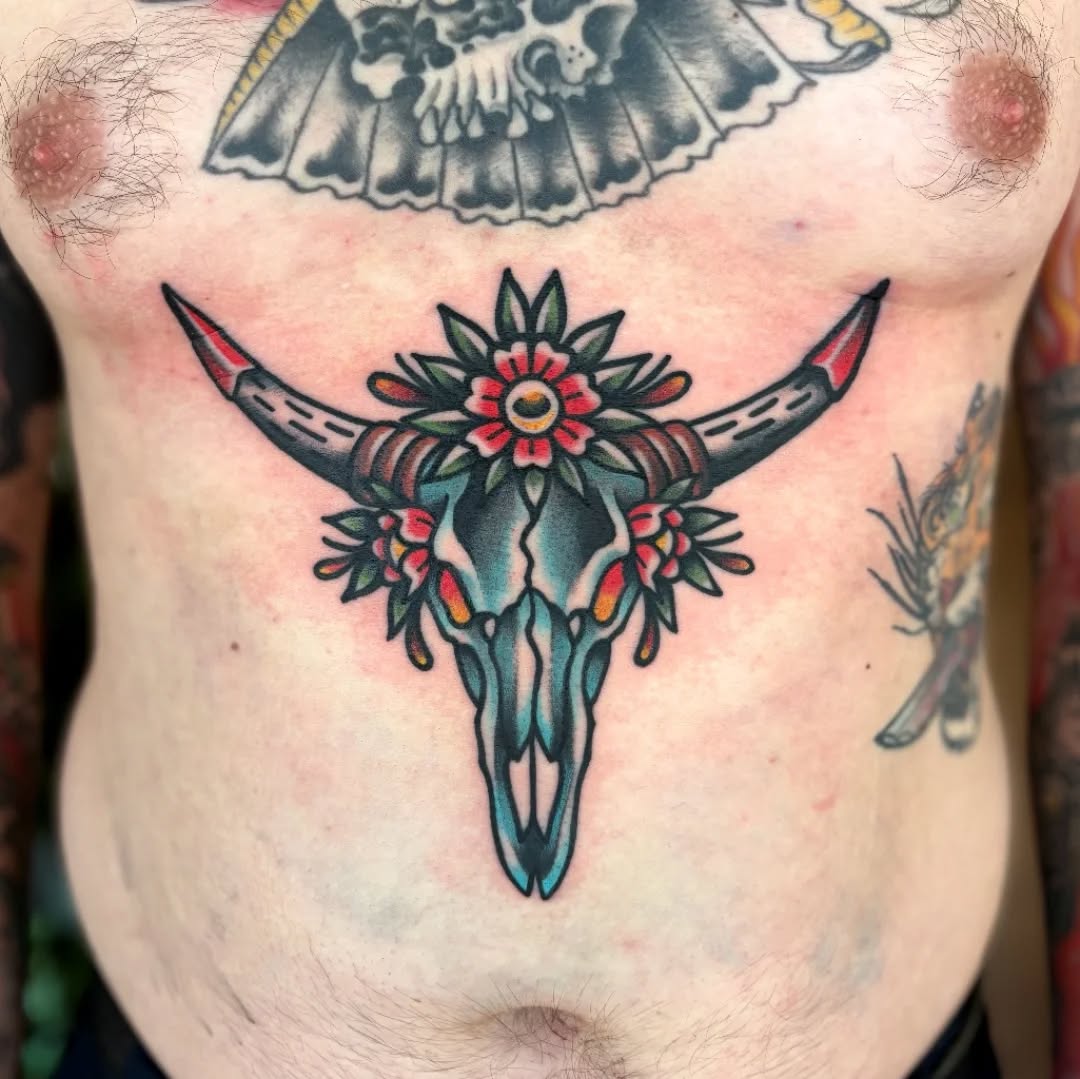 Bold neo-traditional longhorn skull crowned with vibrant florals.