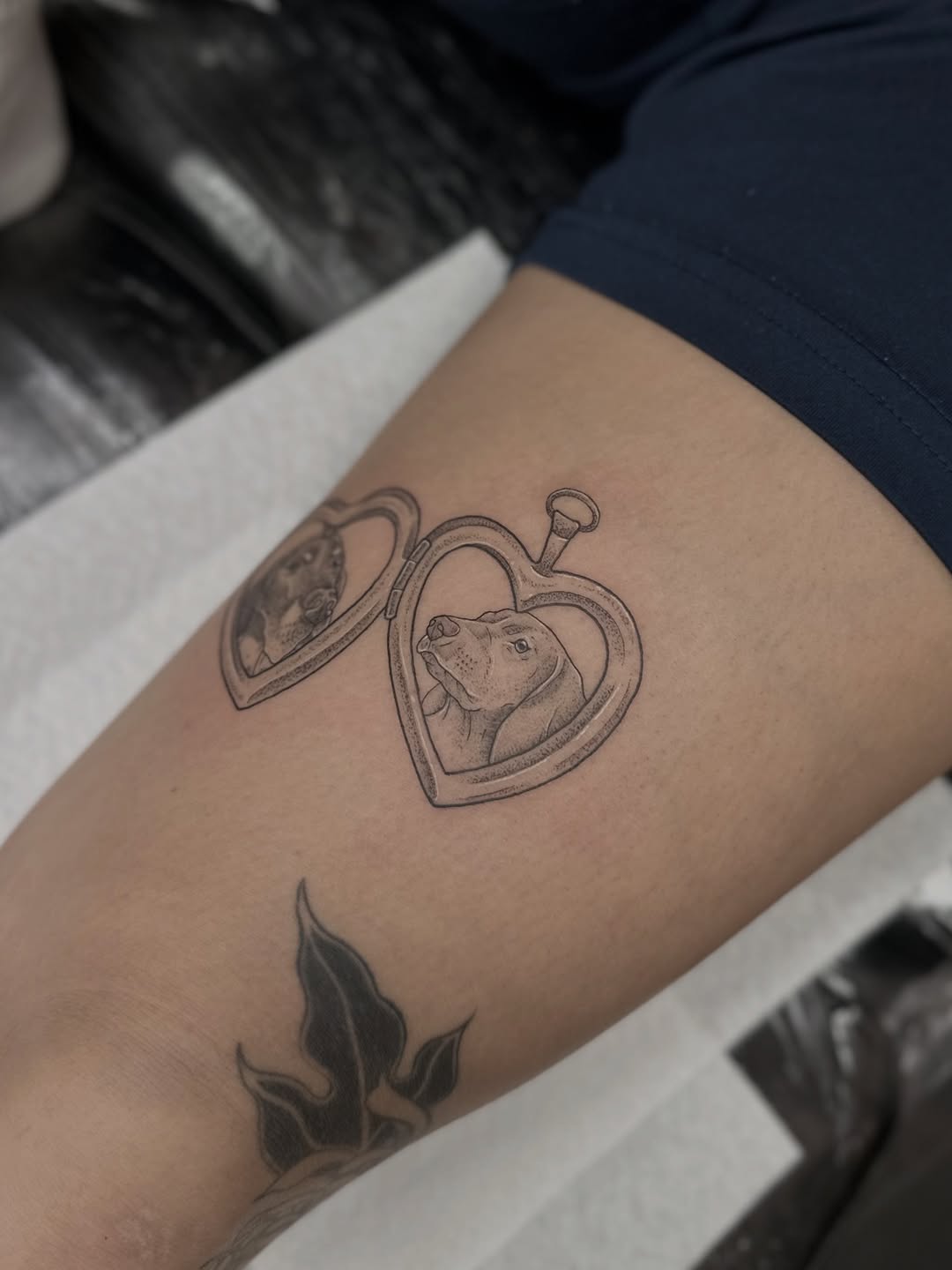Delicate double-heart locket tattoos with detailed dog portraits