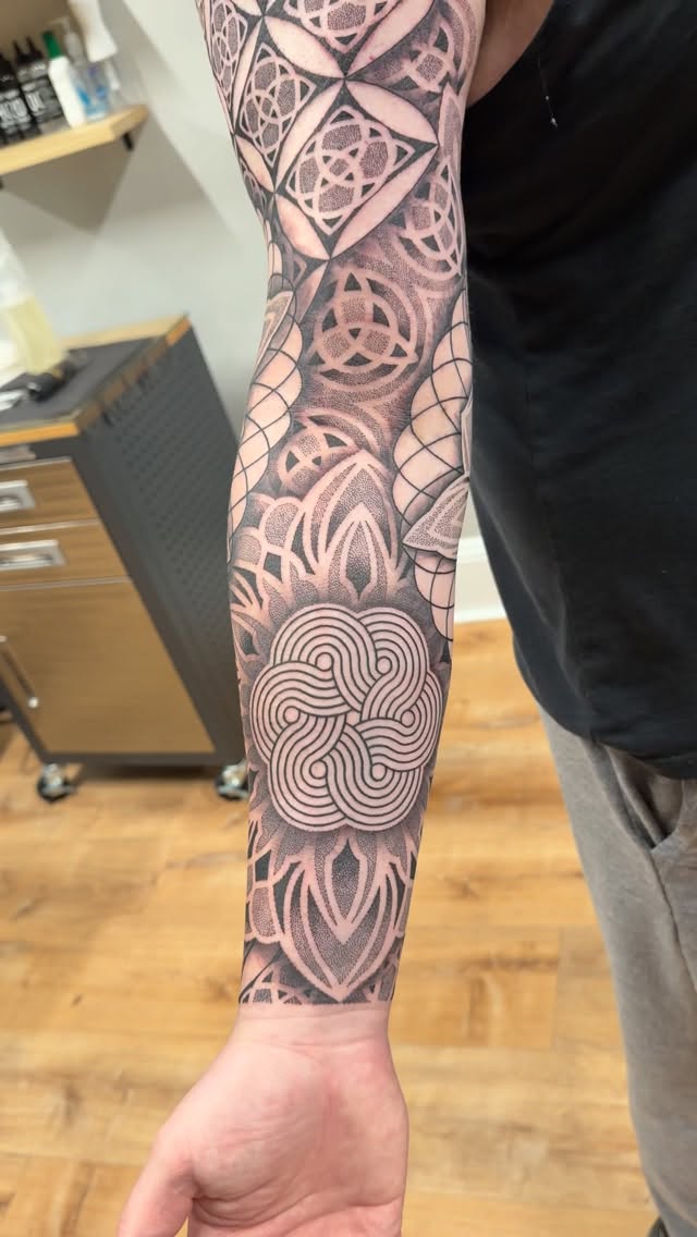Bold Celtic knot-inspired geometric sleeve with dense blackwork shading