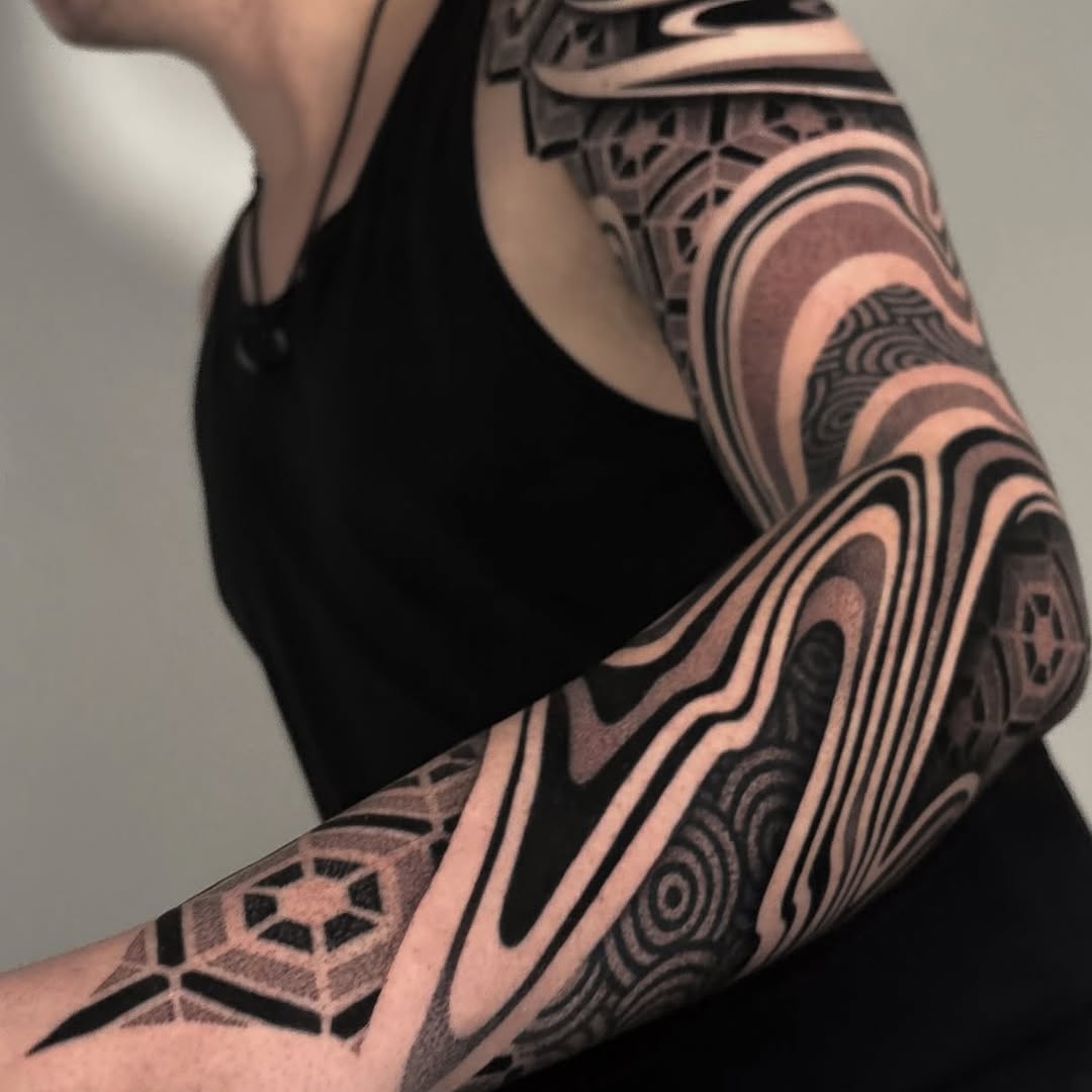 Bold blackwork sleeve with interlocking geometric rings and spirals