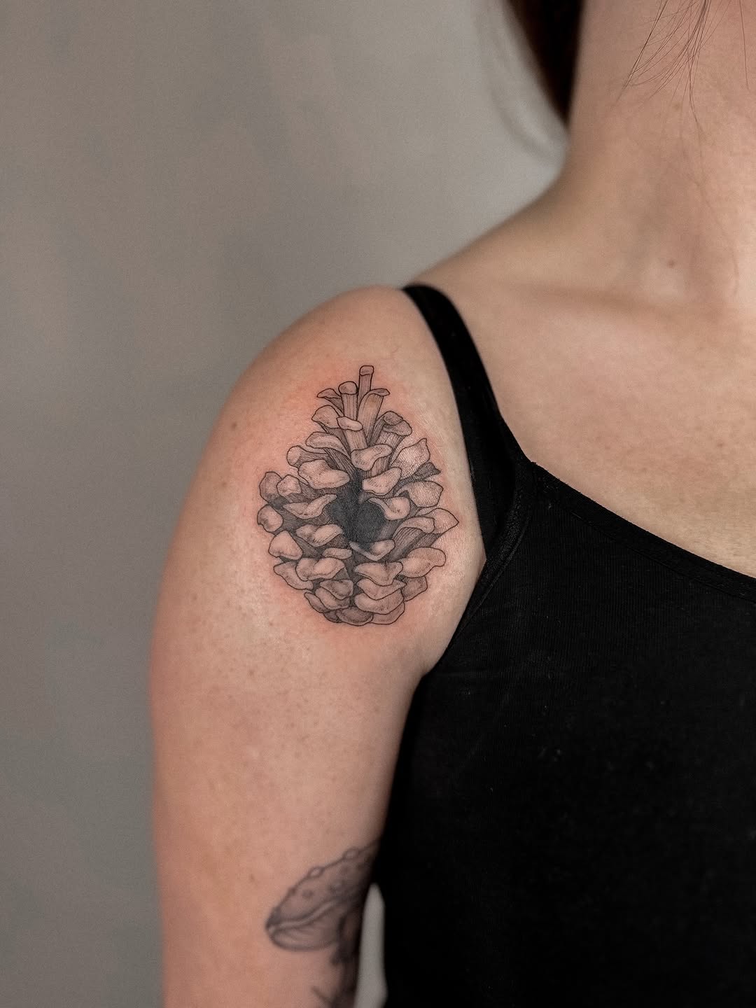 Monochrome hydrangea-like floral cluster on shoulder.