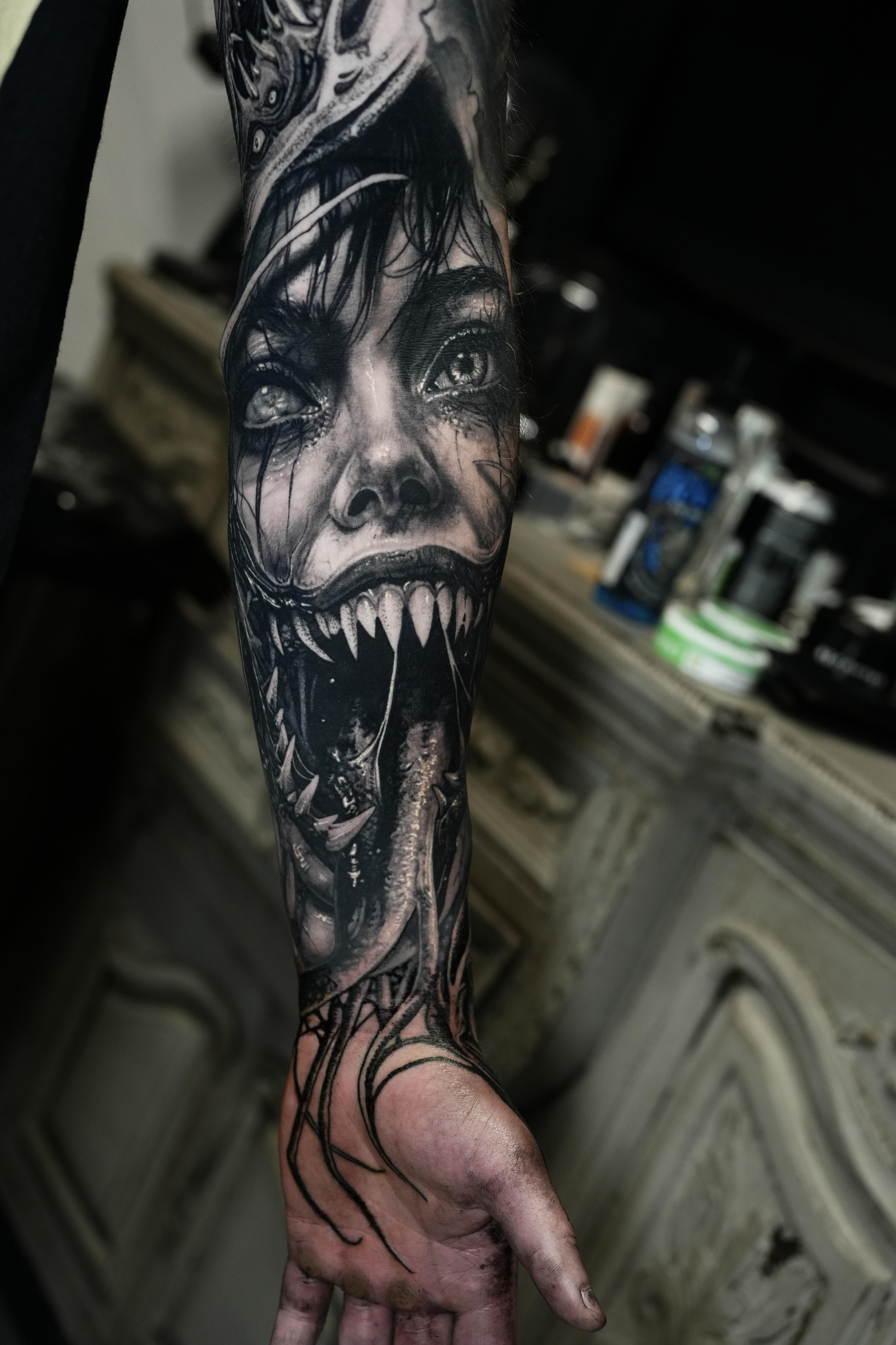 Grim grayscale monster portrait with gnashing, tooth-filled maw.