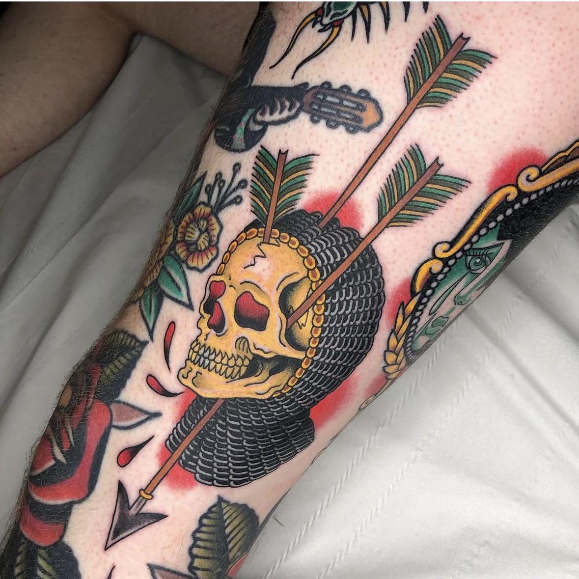 Bold neo-traditional skull pierced by arrows with beaded hoop