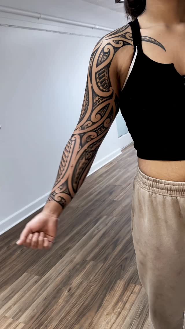 Bold blackwork tribal sleeve with intricate negative-space patterns