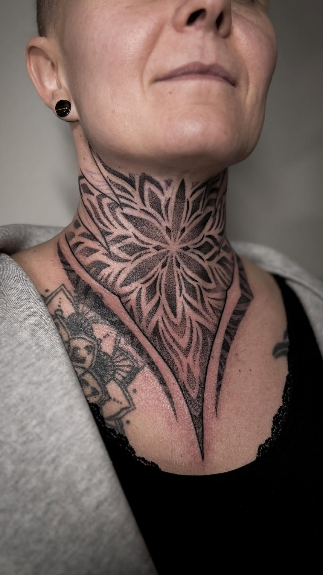 Intricate blackwork neck floral mandala with dot shading.