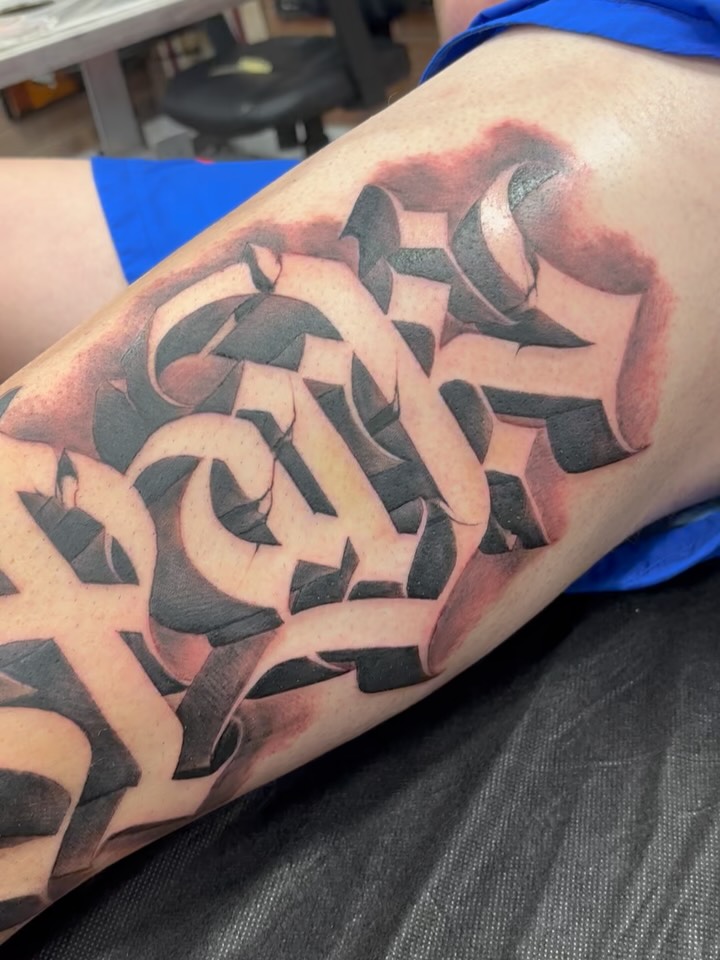 Bold angular blackwork lettering with geometric twists