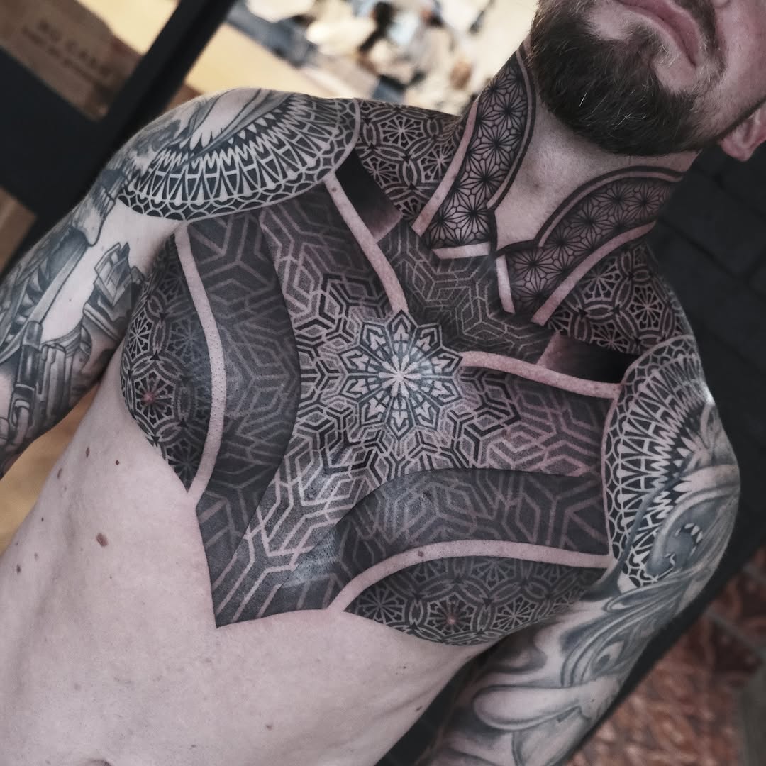 Monumental blackwork geometric chest piece with starburst mandala
