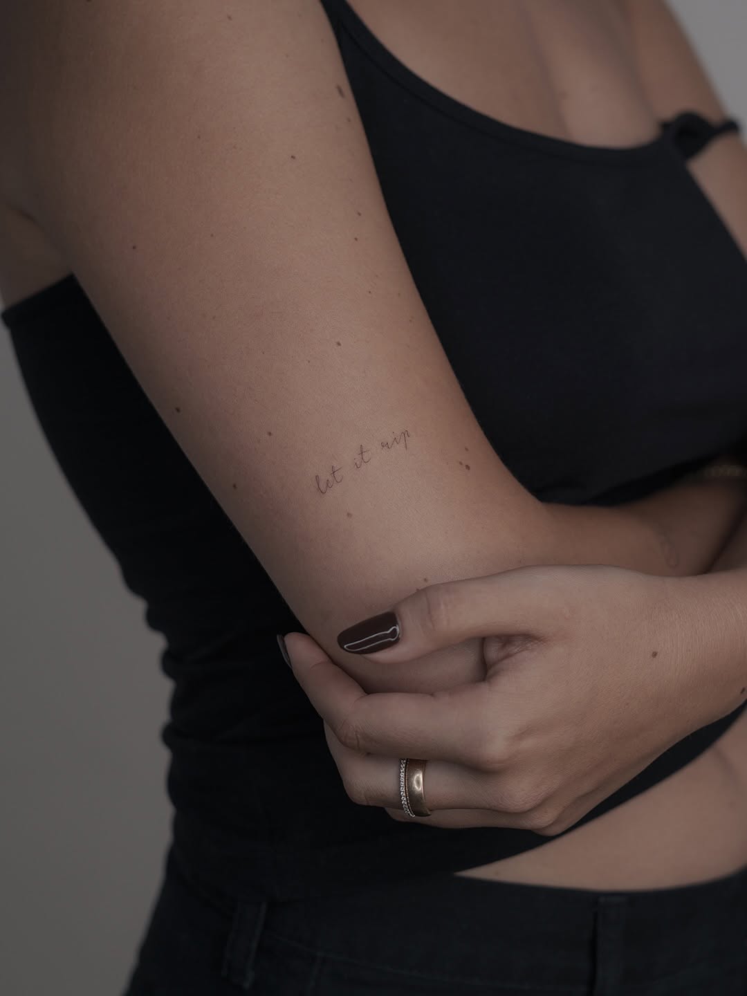 Delicate cursive phrase on inner forearm in fine-line.