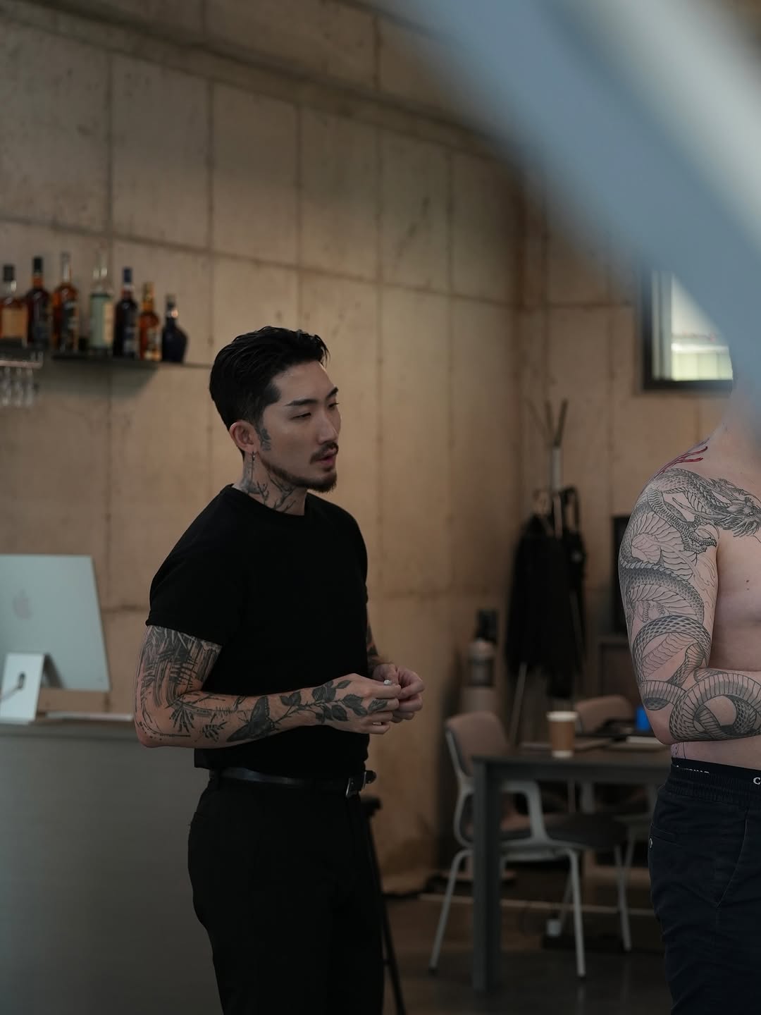 Bold black botanical sleeve tattoos with intricate neckwork.