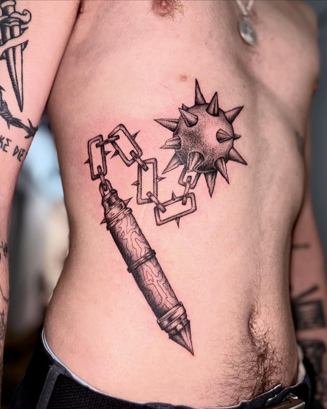Medieval weapon tattoo: spiked ball and chain, bold linework