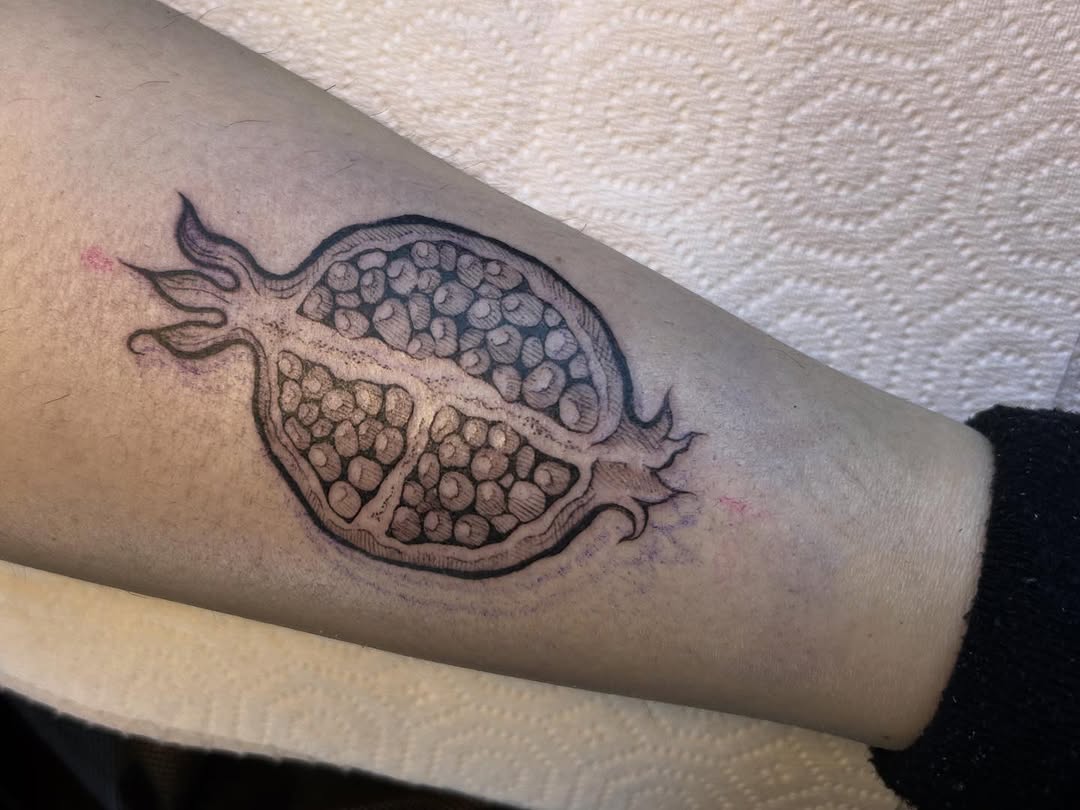 Pomegranate cross-section with bold linework and dot shading.