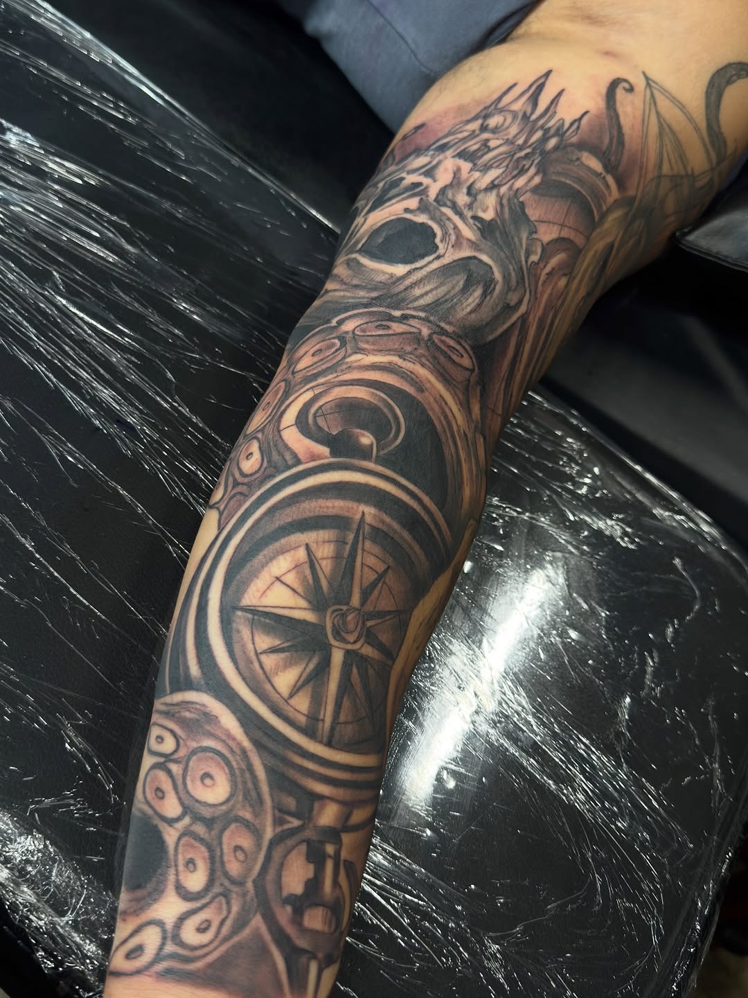 Bold black-and-gray compass rose with gearwork and circular motifs.