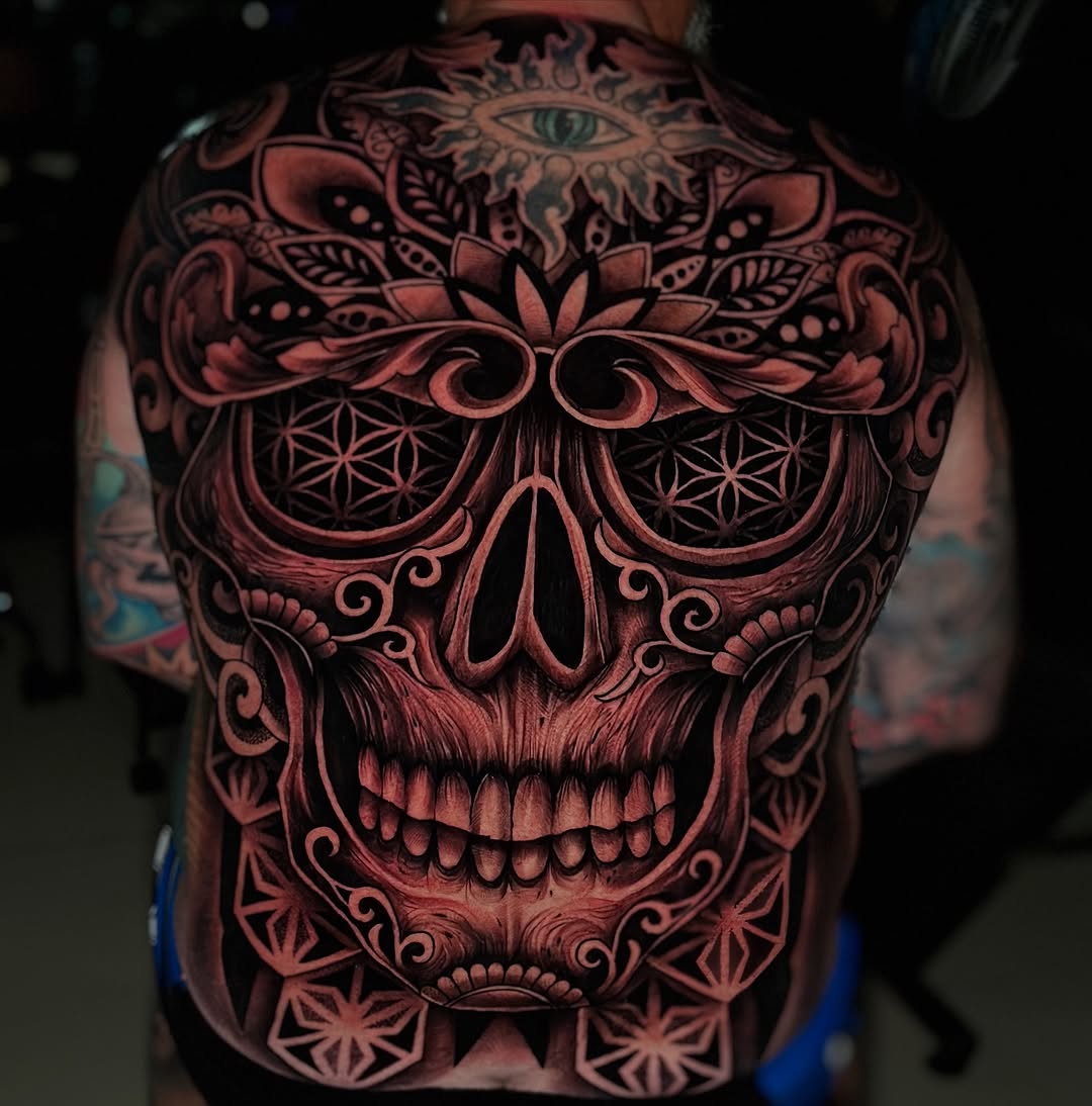 Intricate blackwork skull back tattoo with geometric patterns