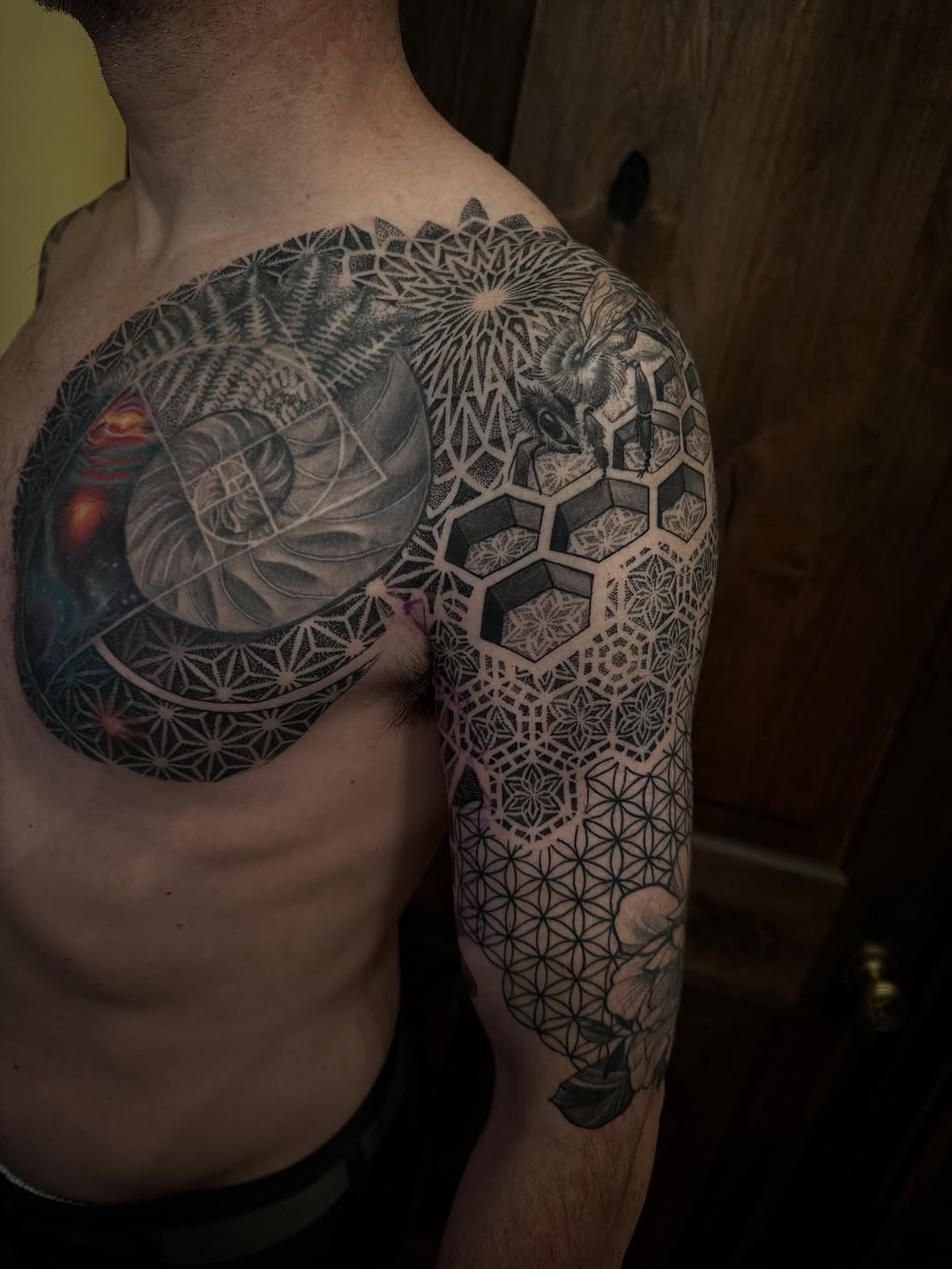 Geometric blackwork sleeve with tessellating hex and floral accents.