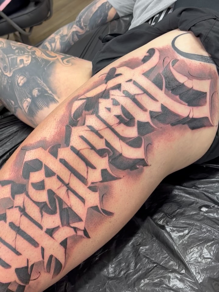 Bold blackletter script with heavy shading along thigh.