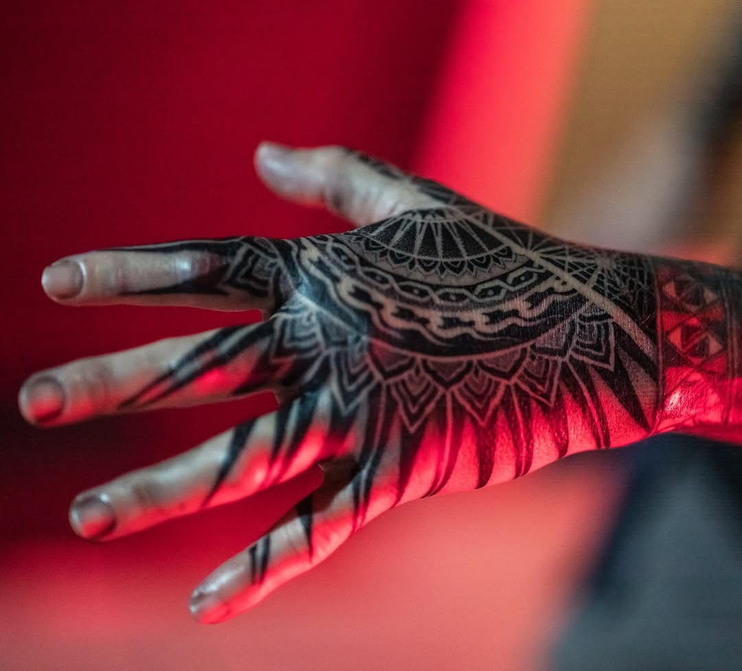 Intricate black mandala pattern on the hand.