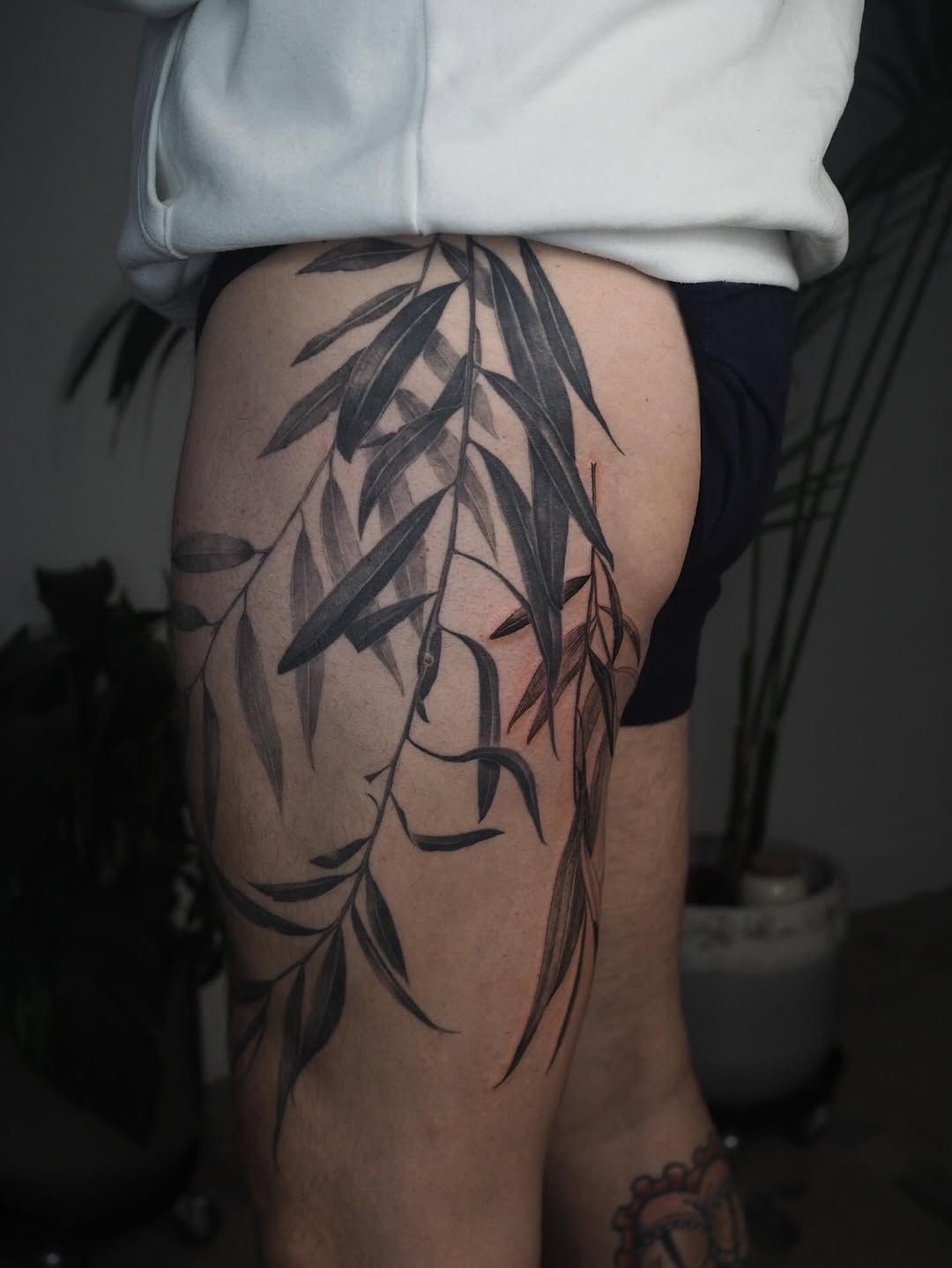 Dramatic grayscale willow leaves wrap outer thigh.