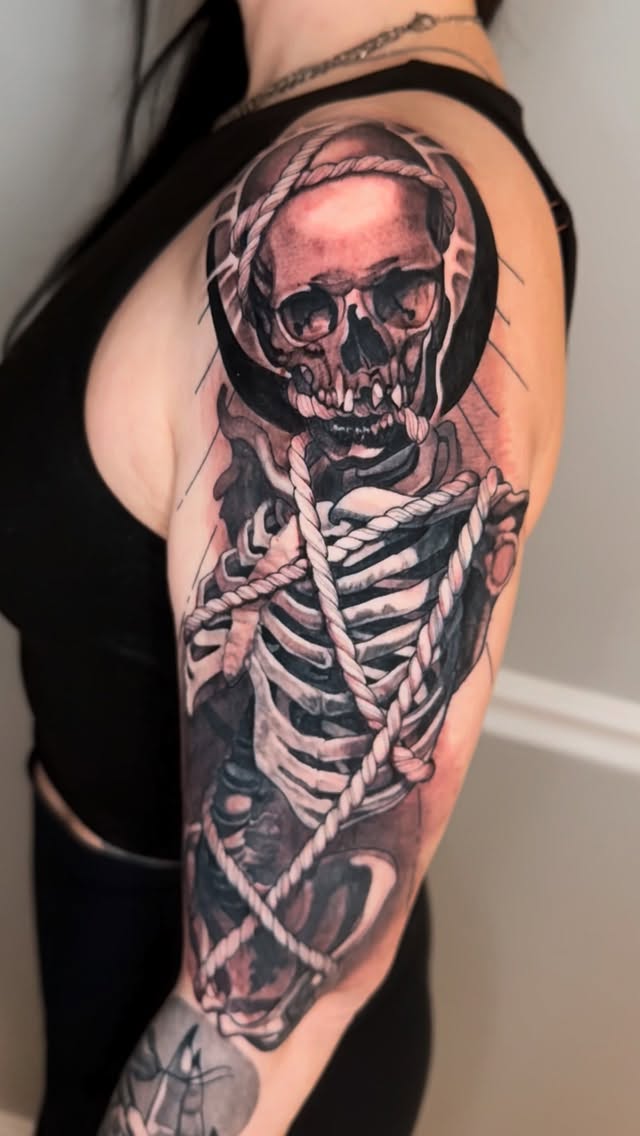 Monochrome skeletal figure wrapped in rugged rope.