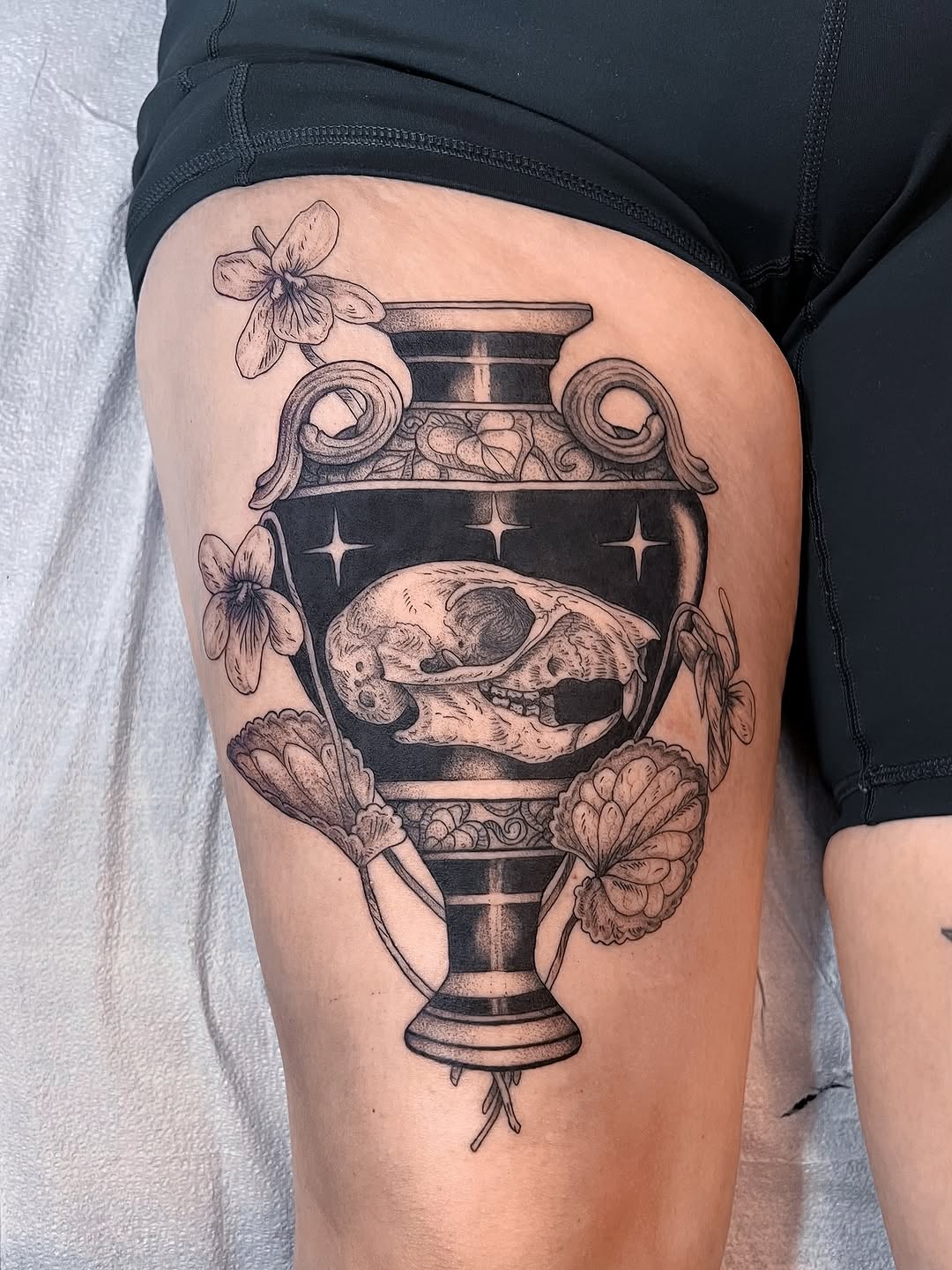 Gothic black-and-gray urn with skull and violets.