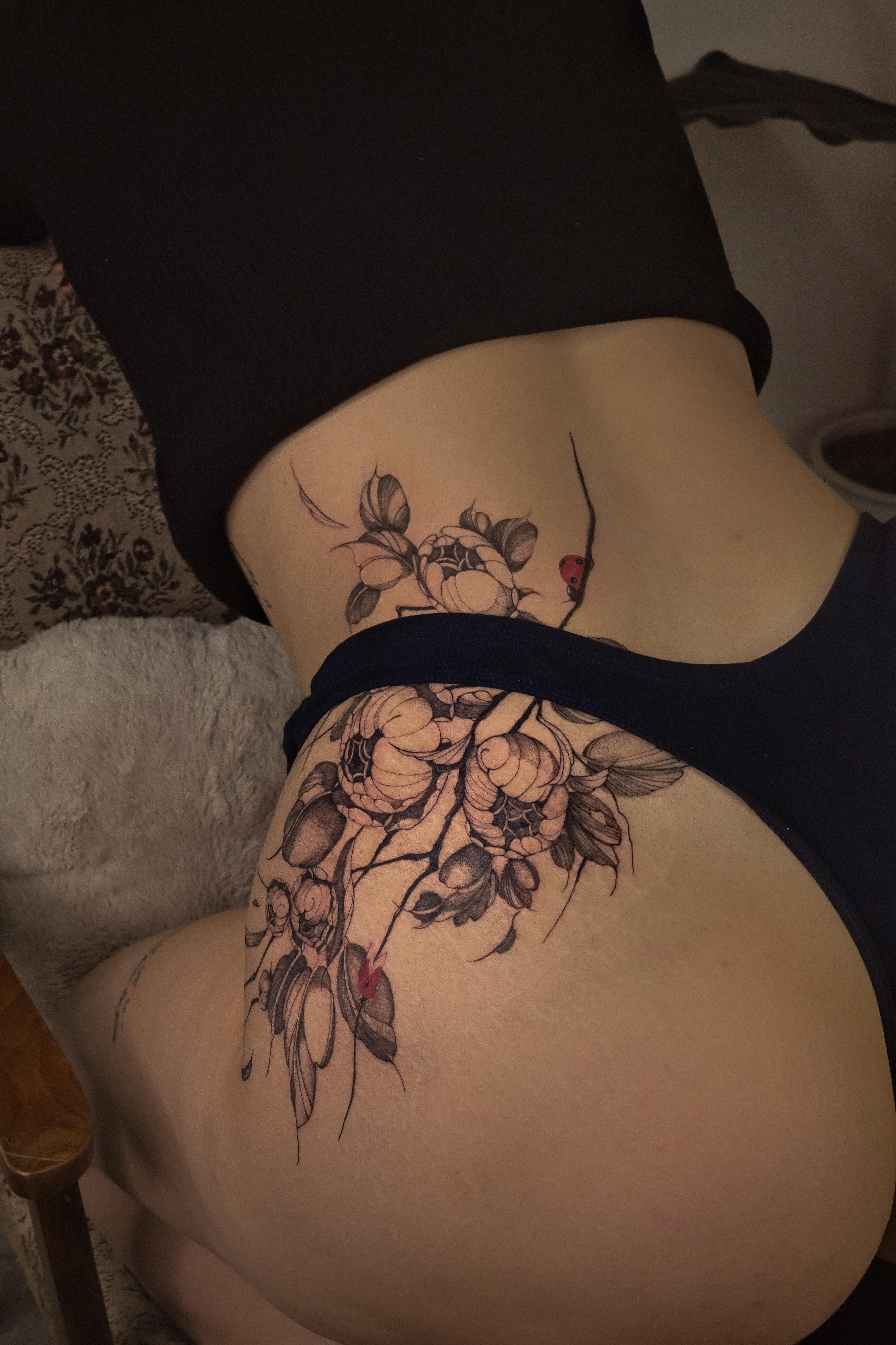 Delicate botanical floral vine wrapping hip with peonies