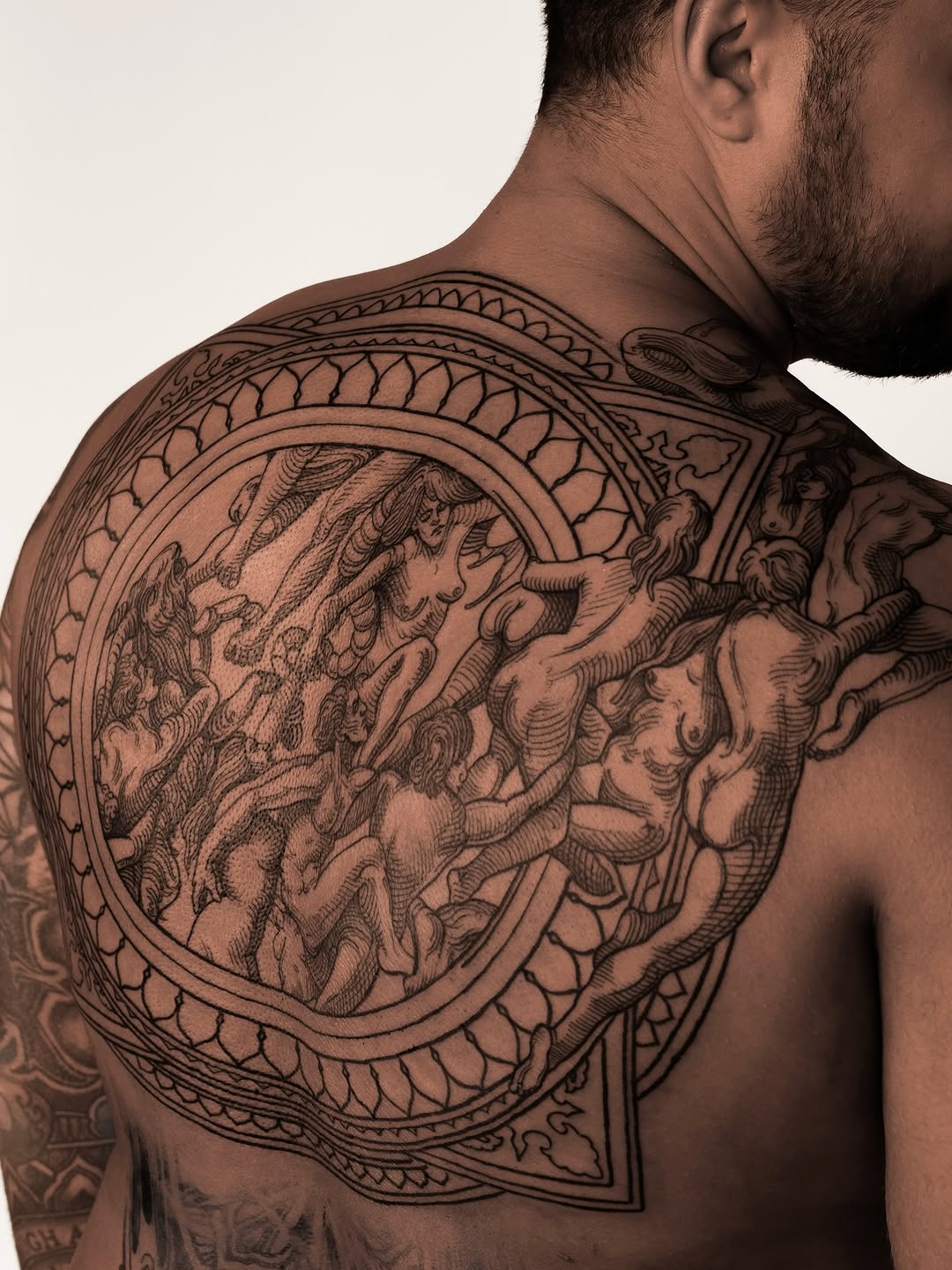 Intricate circular medallion with mythic nude figures.