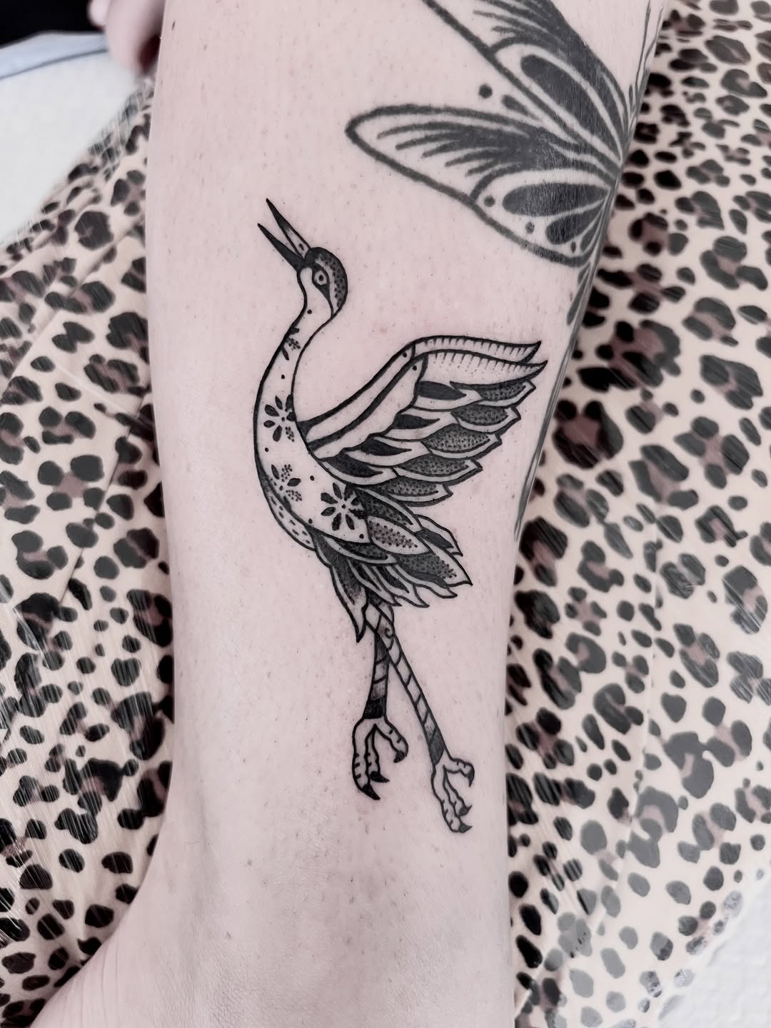 Elegant blackwork crane with fine ornamental patterns on ankle