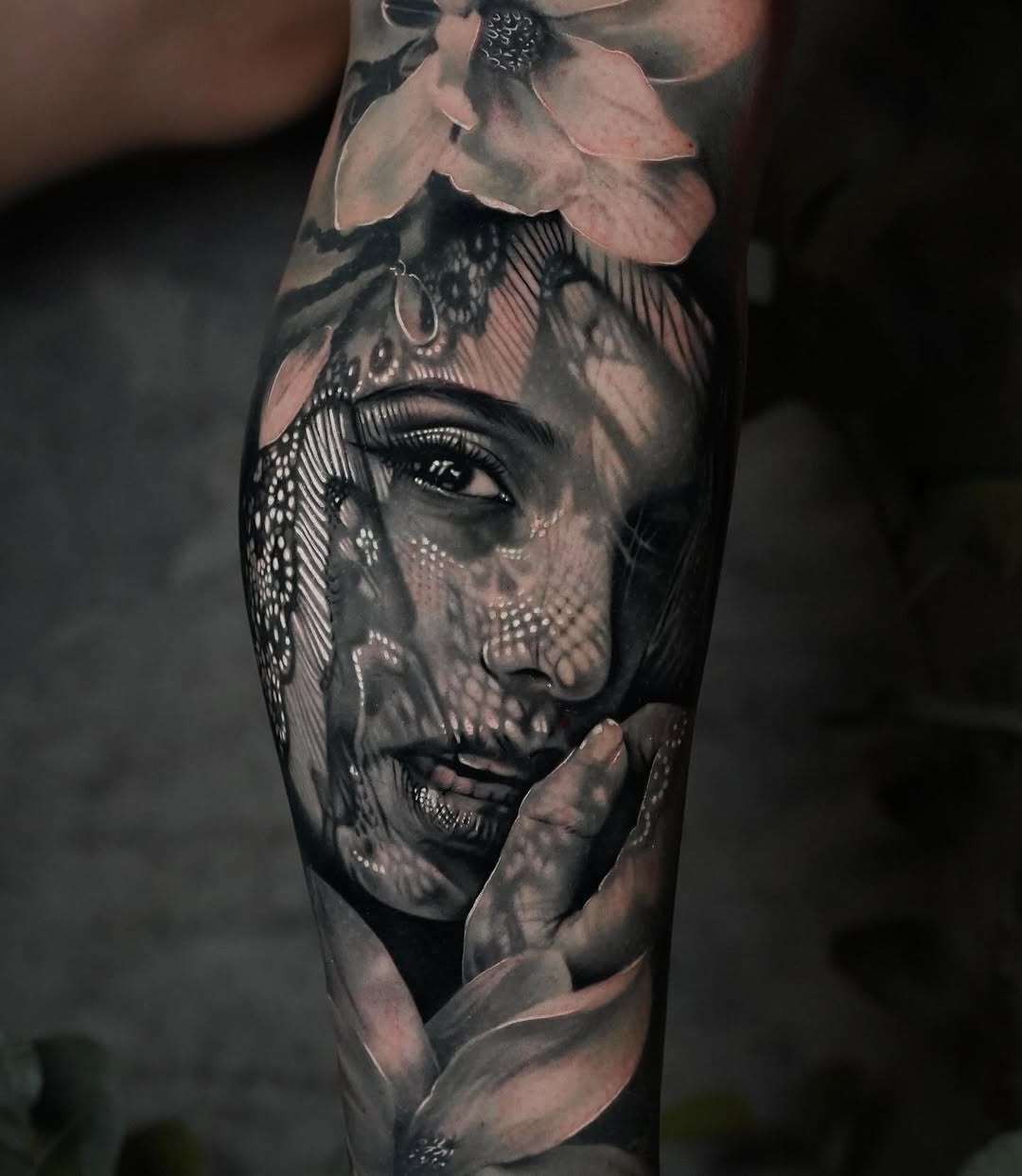 Hyper-realistic lace-overlay portrait on forearm, moody and evocative.