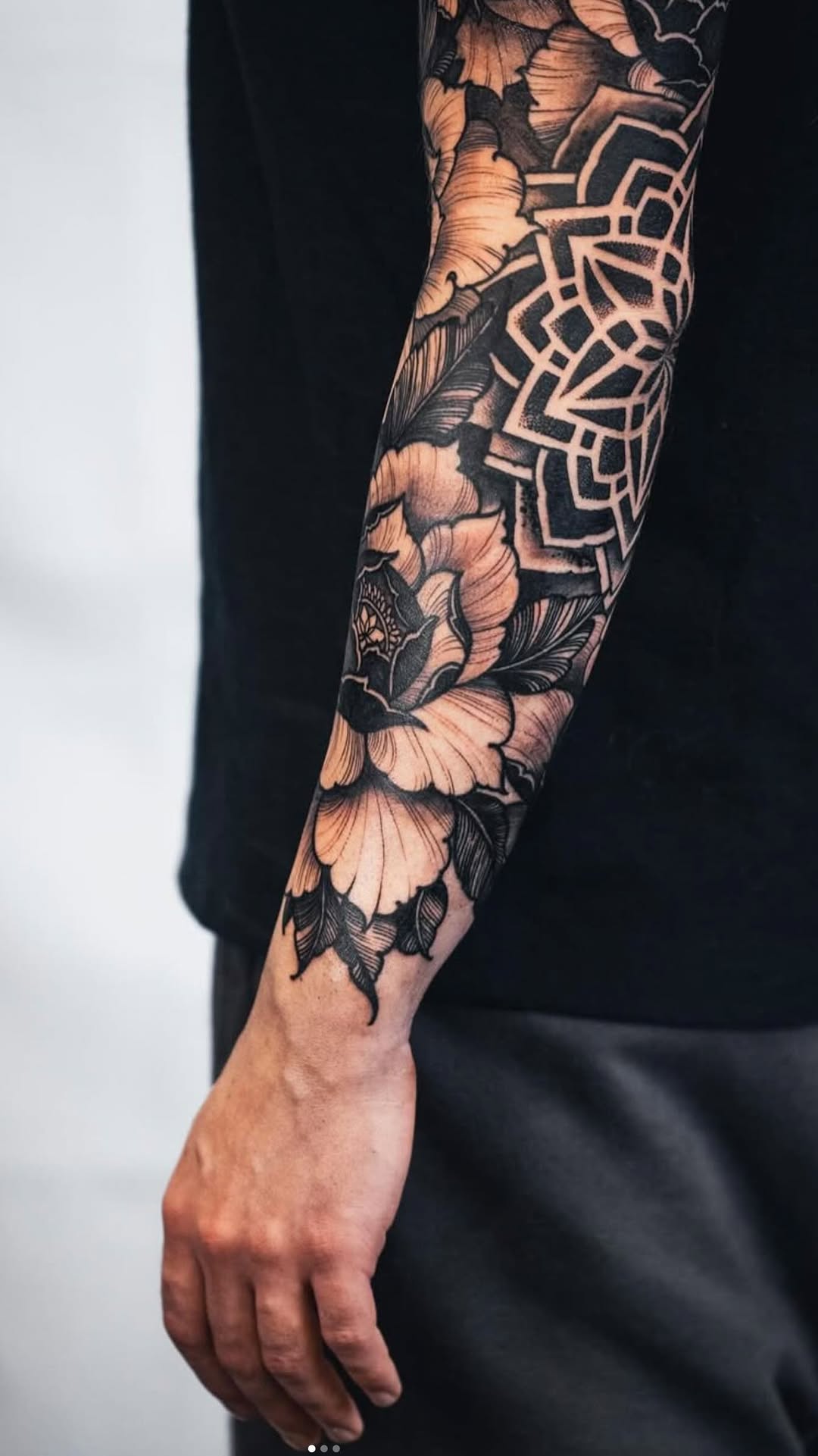 Intricate black floral sleeve with a bold geometric mandala