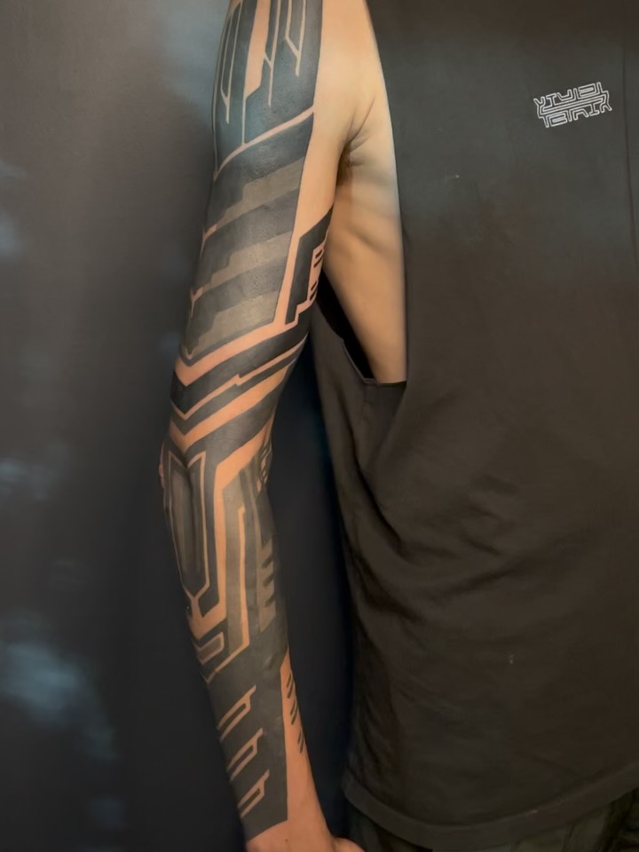 Cyber-geometric blackwork sleeve with bold negative-space motifs