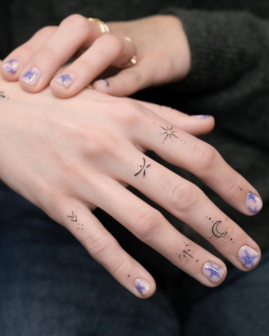 Delicate minimalist finger symbols with stars and crescents.