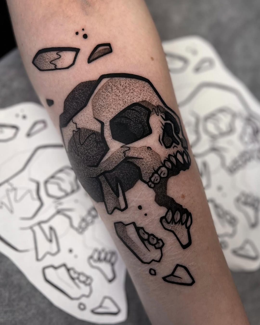 Bold blackwork skull with fragmented pieces and dot shading