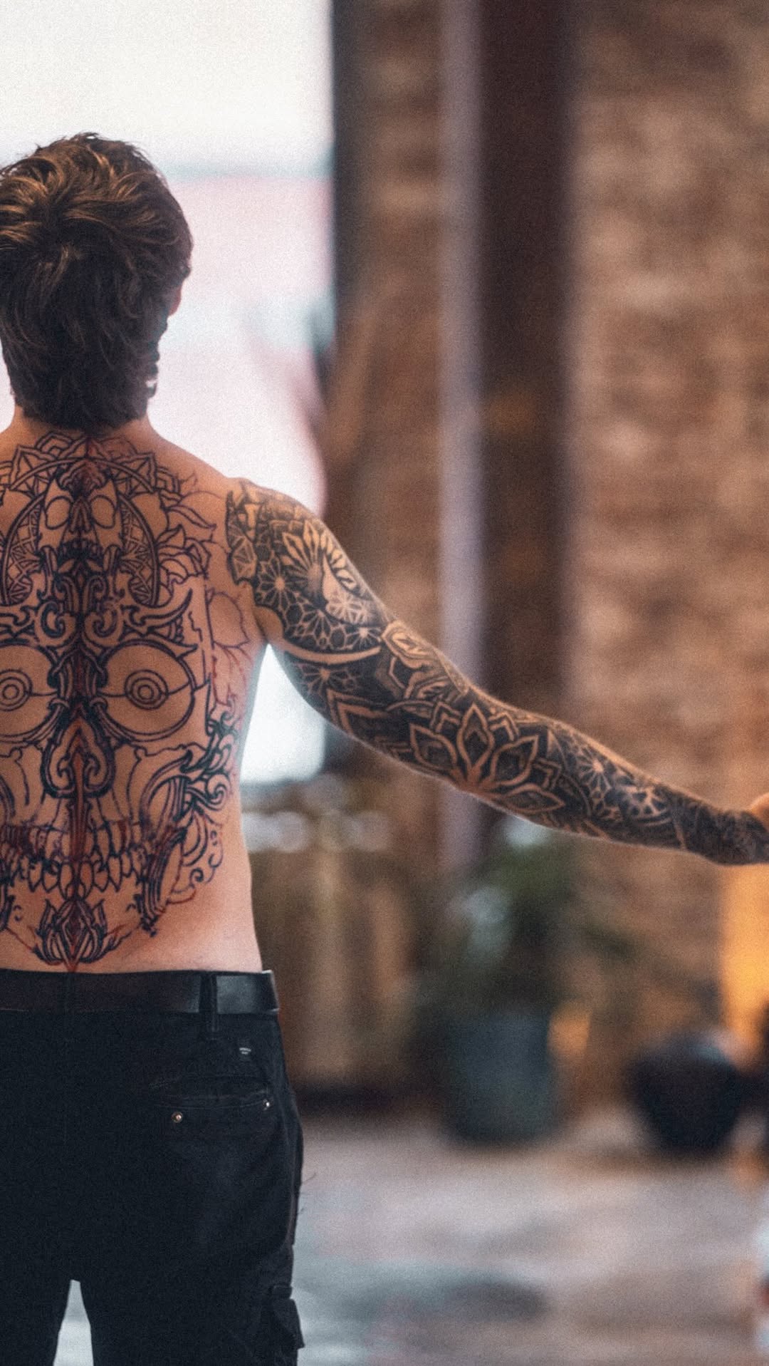 Intricate blackwork backpiece with skull motif and geometric flourishes