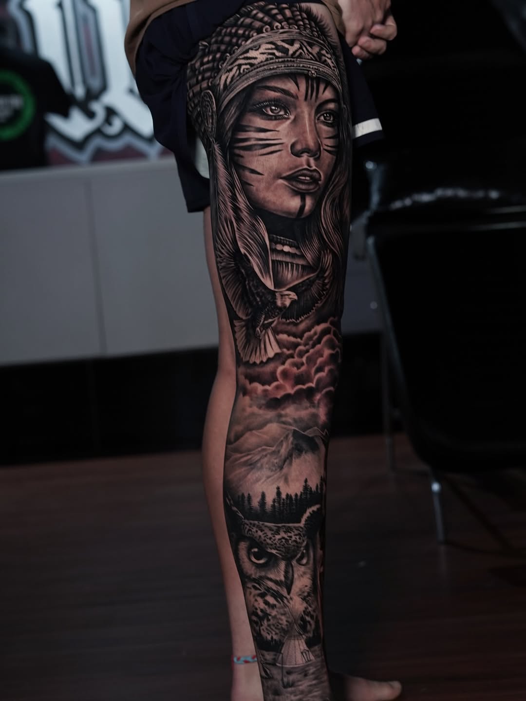 Hyper-detailed black-and-gray leg sleeve featuring portrait and wilderness