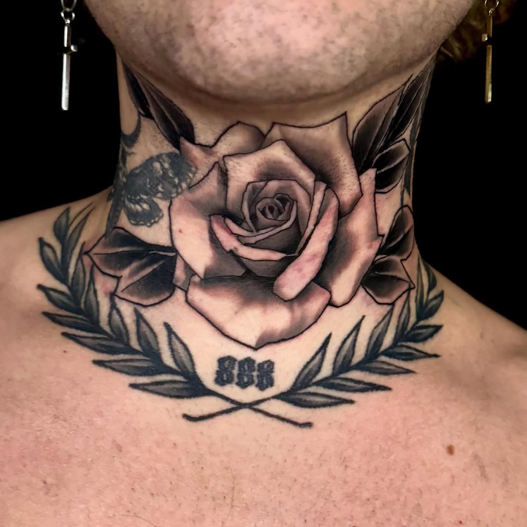 Bold black-and-gray rose with laurel wreath collar.