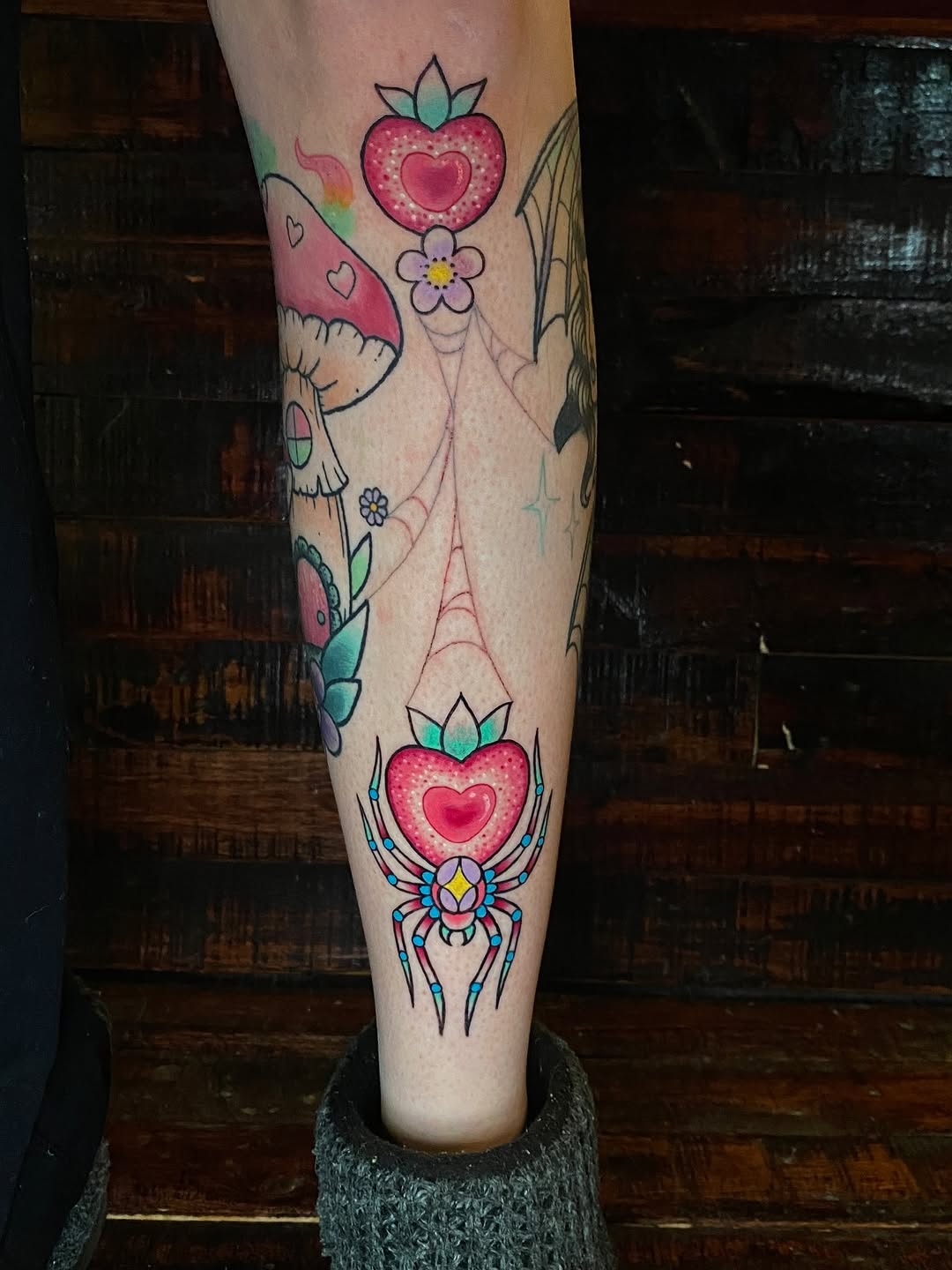 Vibrant neo-traditional leg sleeve with heart motifs and spider centerpiece