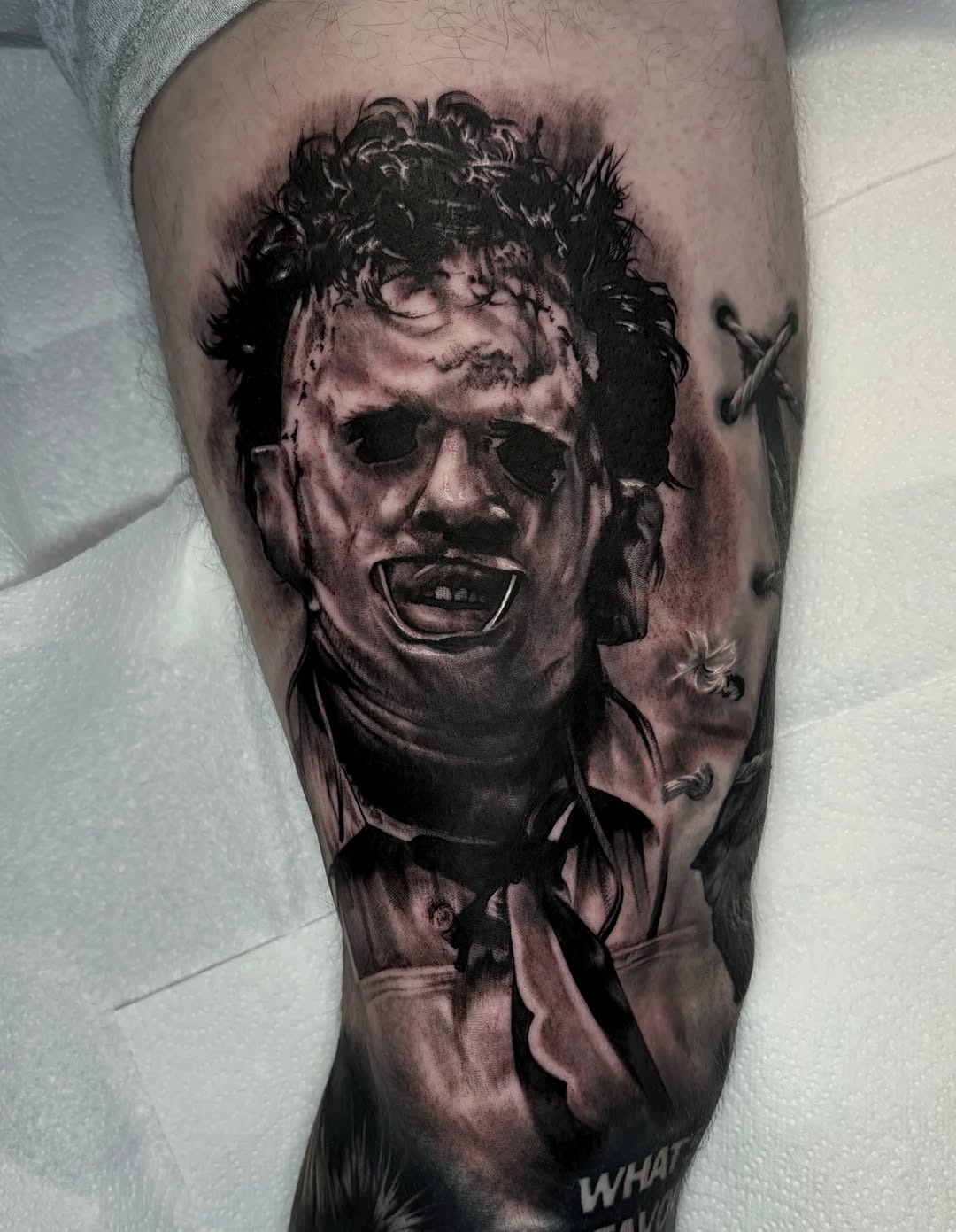 Hyper-detailed black-and-gray Leatherface portrait with eerie expression.