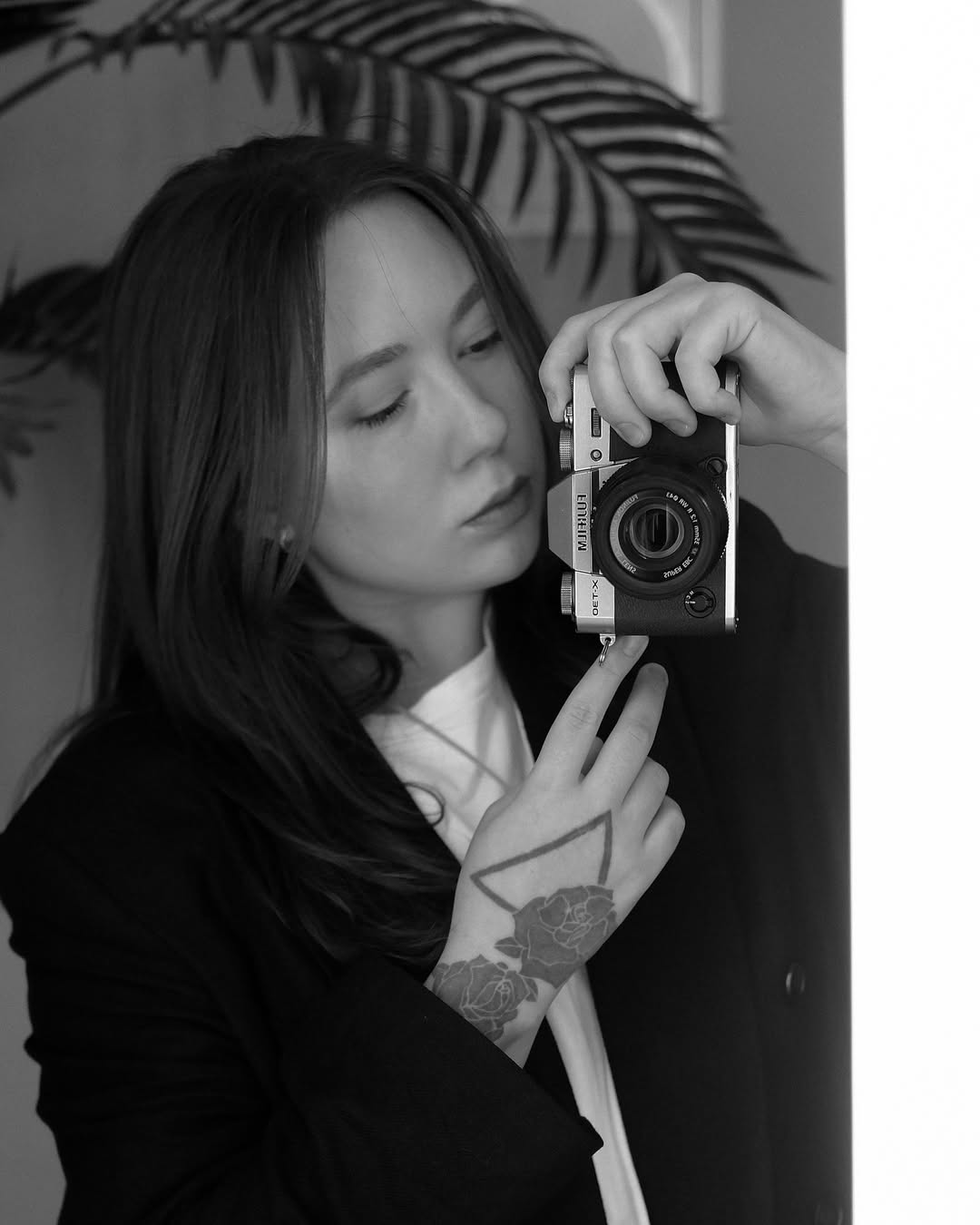 Geometric triangle frame enclosing a blooming rose cluster on hand.