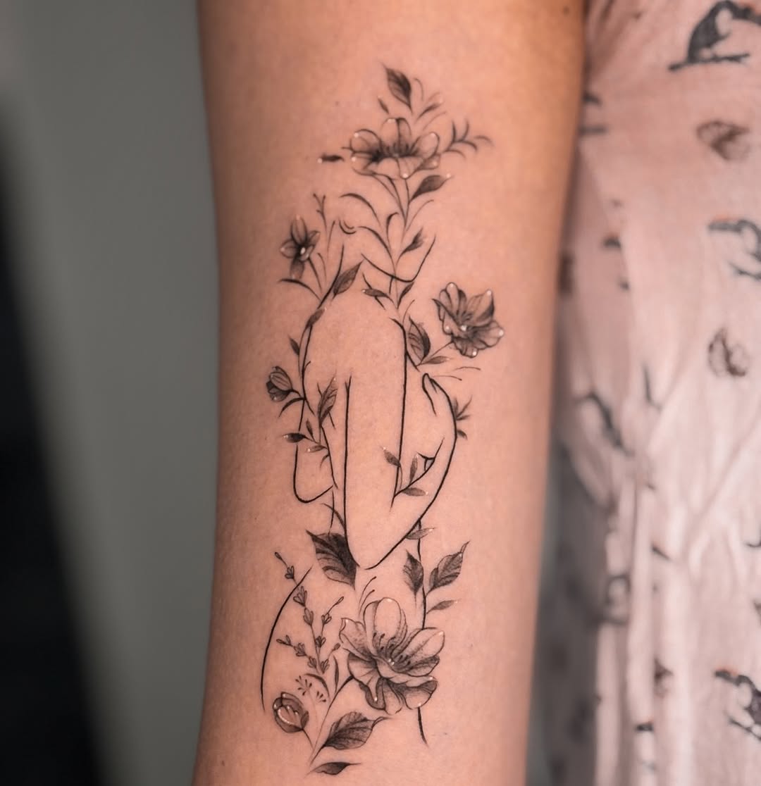 Delicate floral vines wrap around a minimalist hand silhouette
