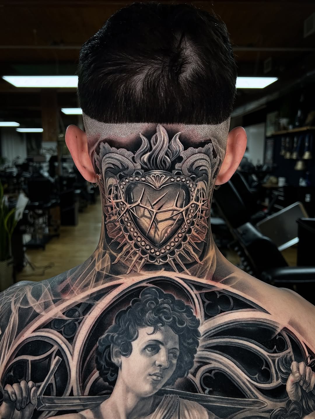 Intricate black-and-gray Sacred Heart backpiece with ornate frame