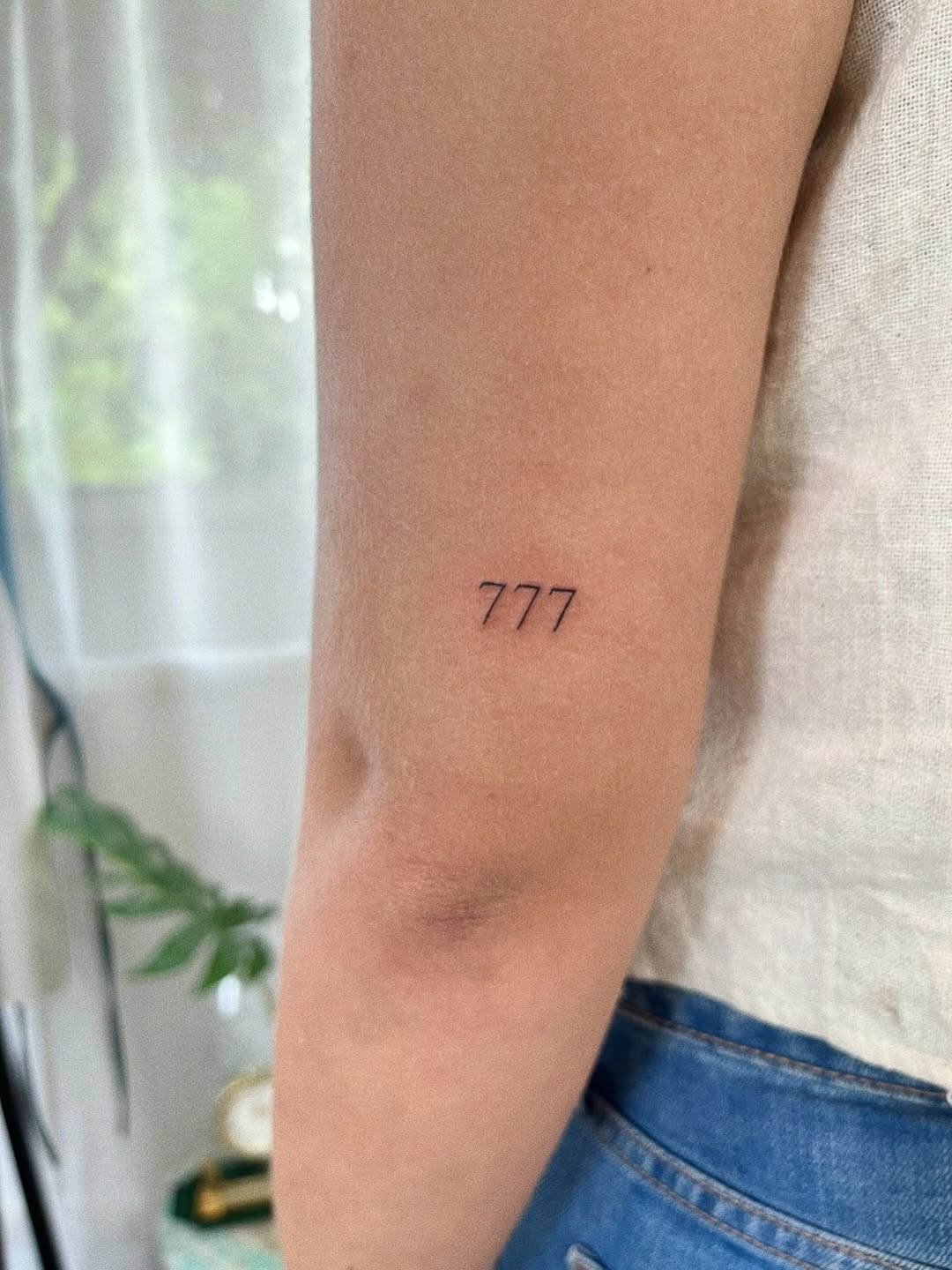 Delicate fineline trio of sevens on the forearm