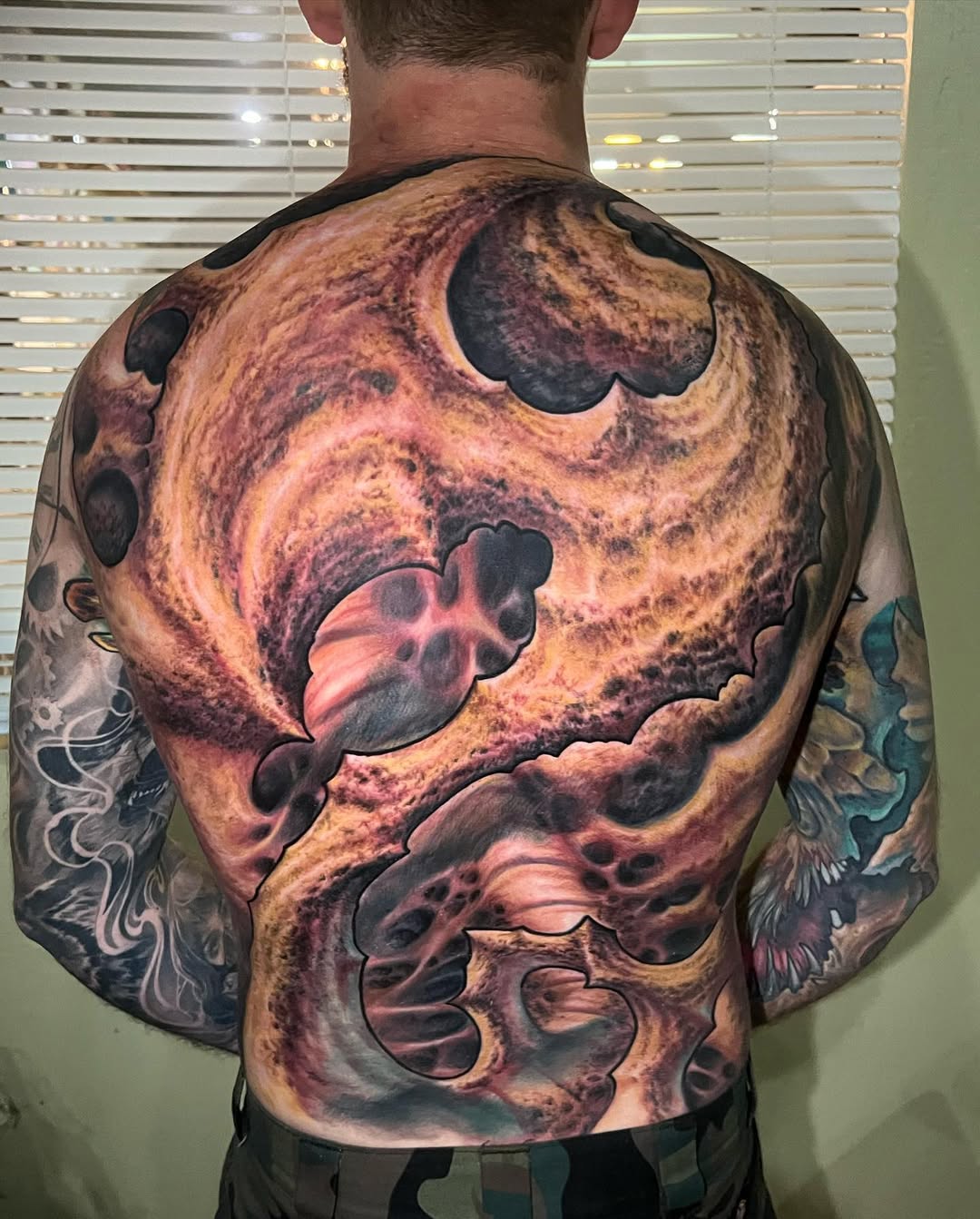 Cosmic biomechanical back piece with swirling nebulae