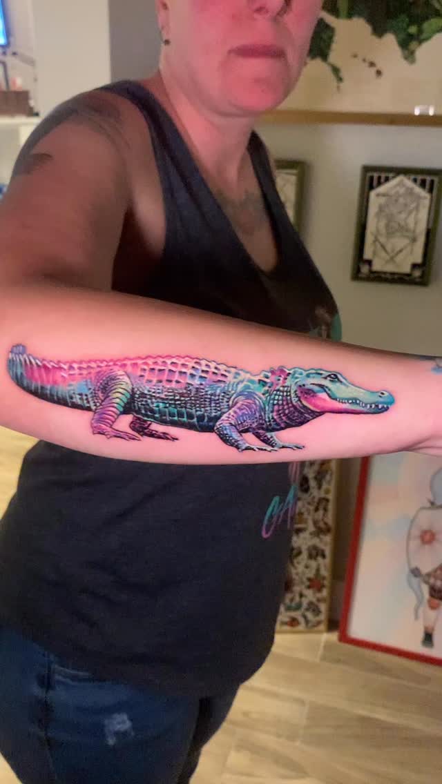 Vibrant neon alligator tattoo with gradient scales.