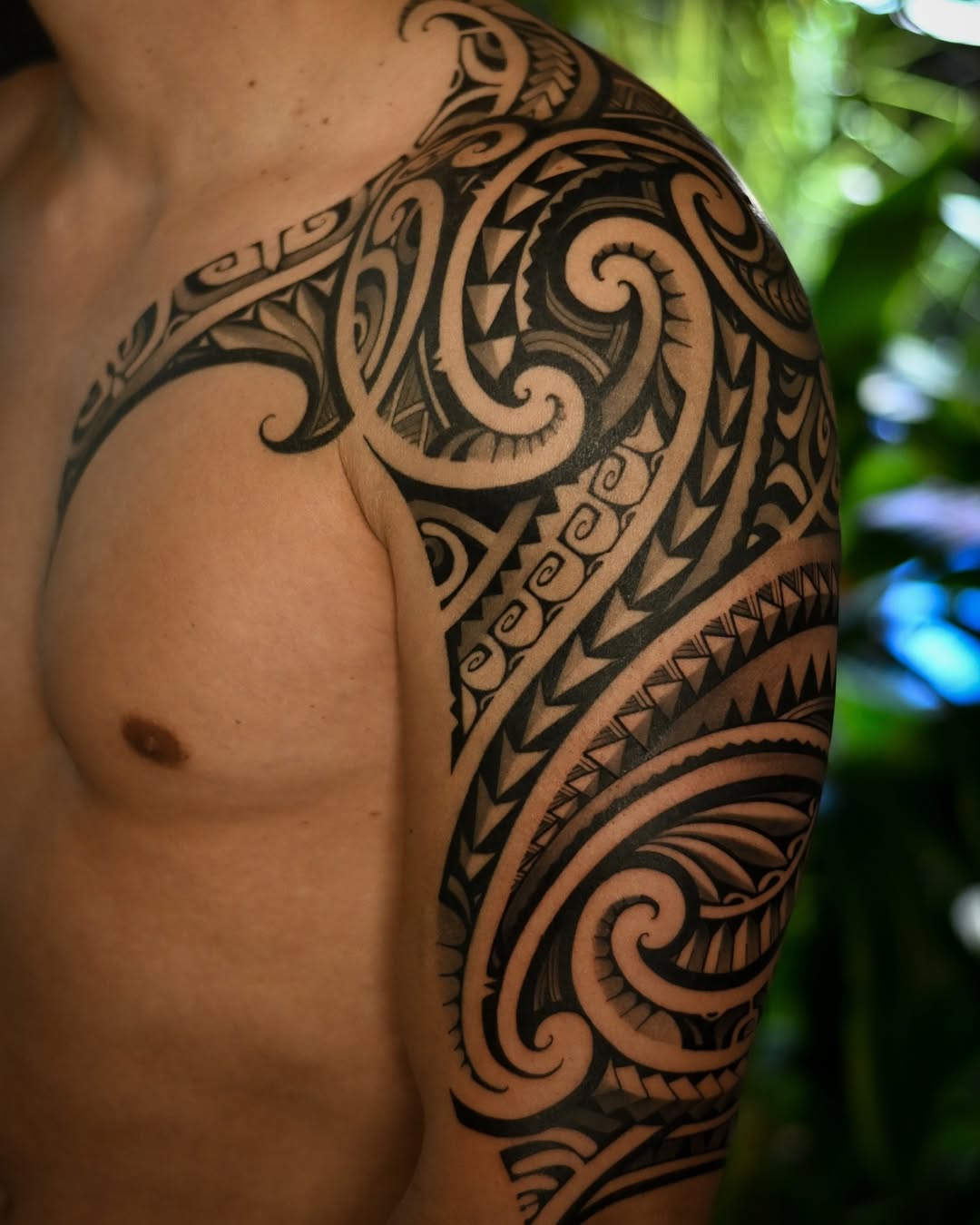Bold Polynesian blackwork sleeve with swirling tribal motifs