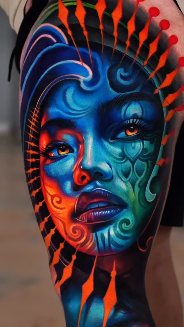 Colorful face tattoo on thigh