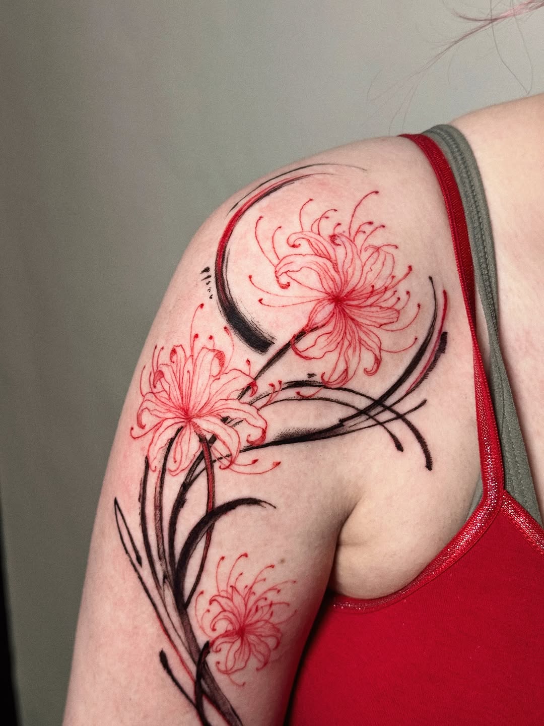 Dynamic black-and-red floral shoulder piece with spider lilies